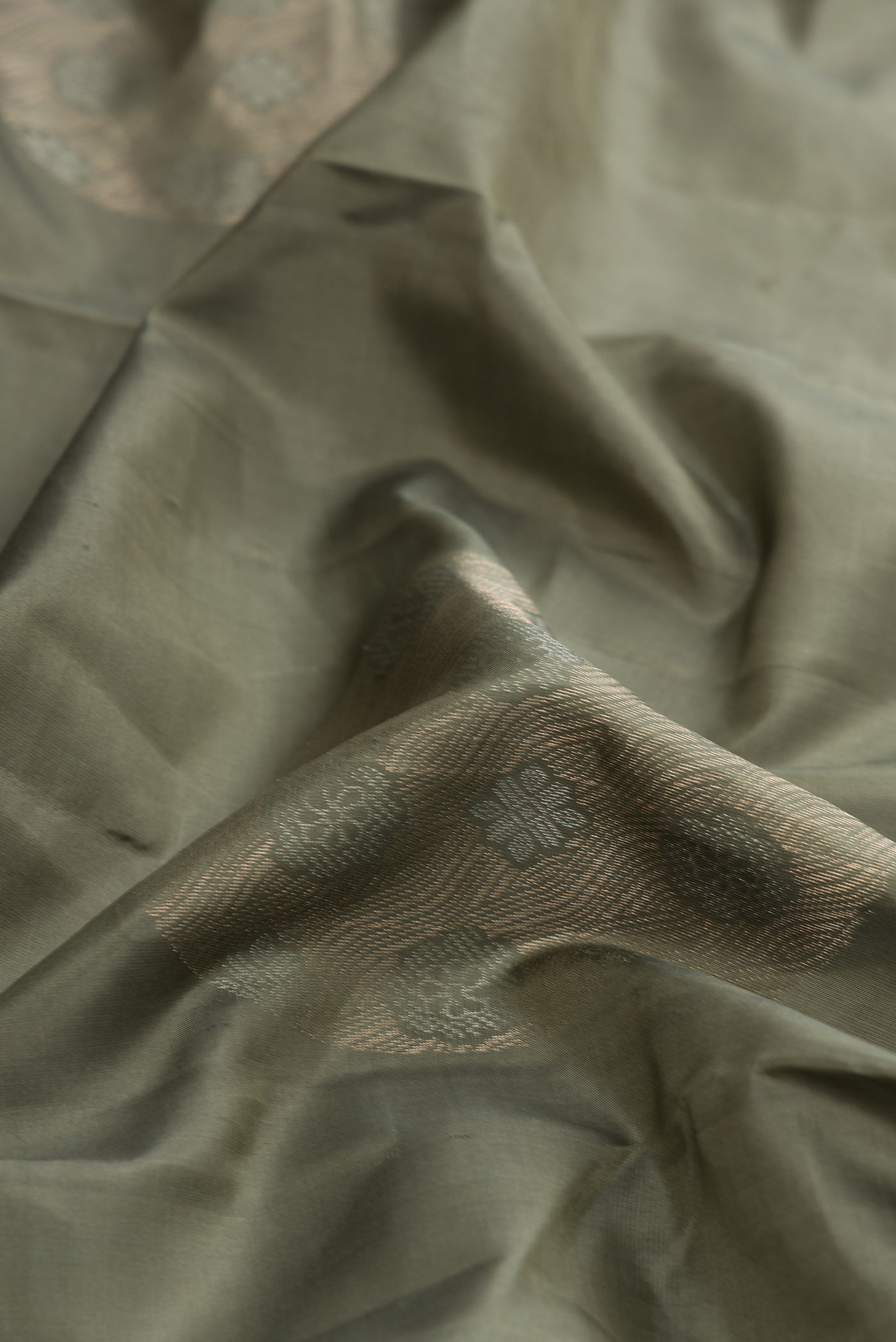 Close up of Brown Dual Tone Soft Silk Saree with Zari Butta on the body and Without Border.  displaying folds