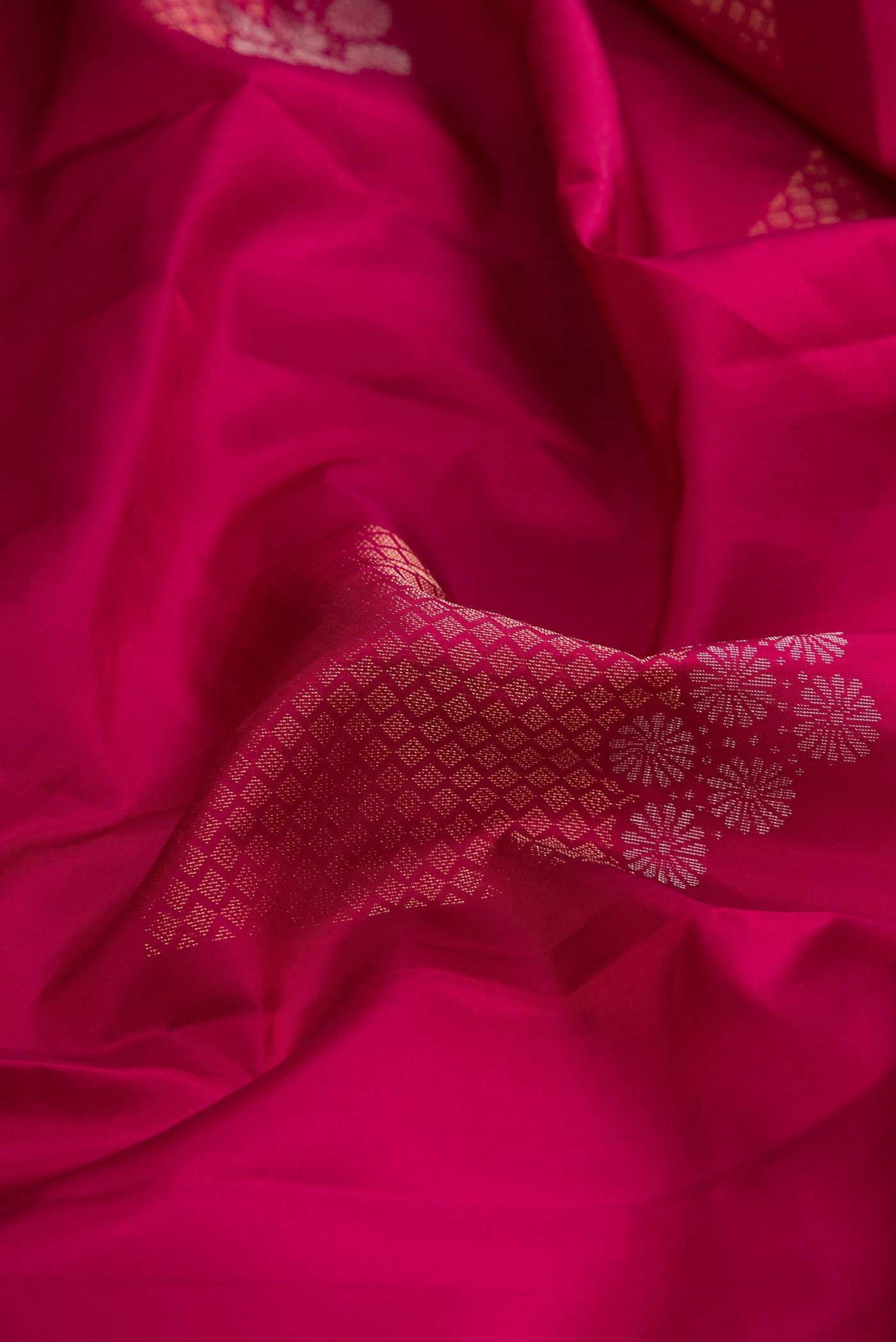 Close up of Magenta Dual Tone Soft Silk Saree with Zari Butta on the body and Without Border.  displaying folds