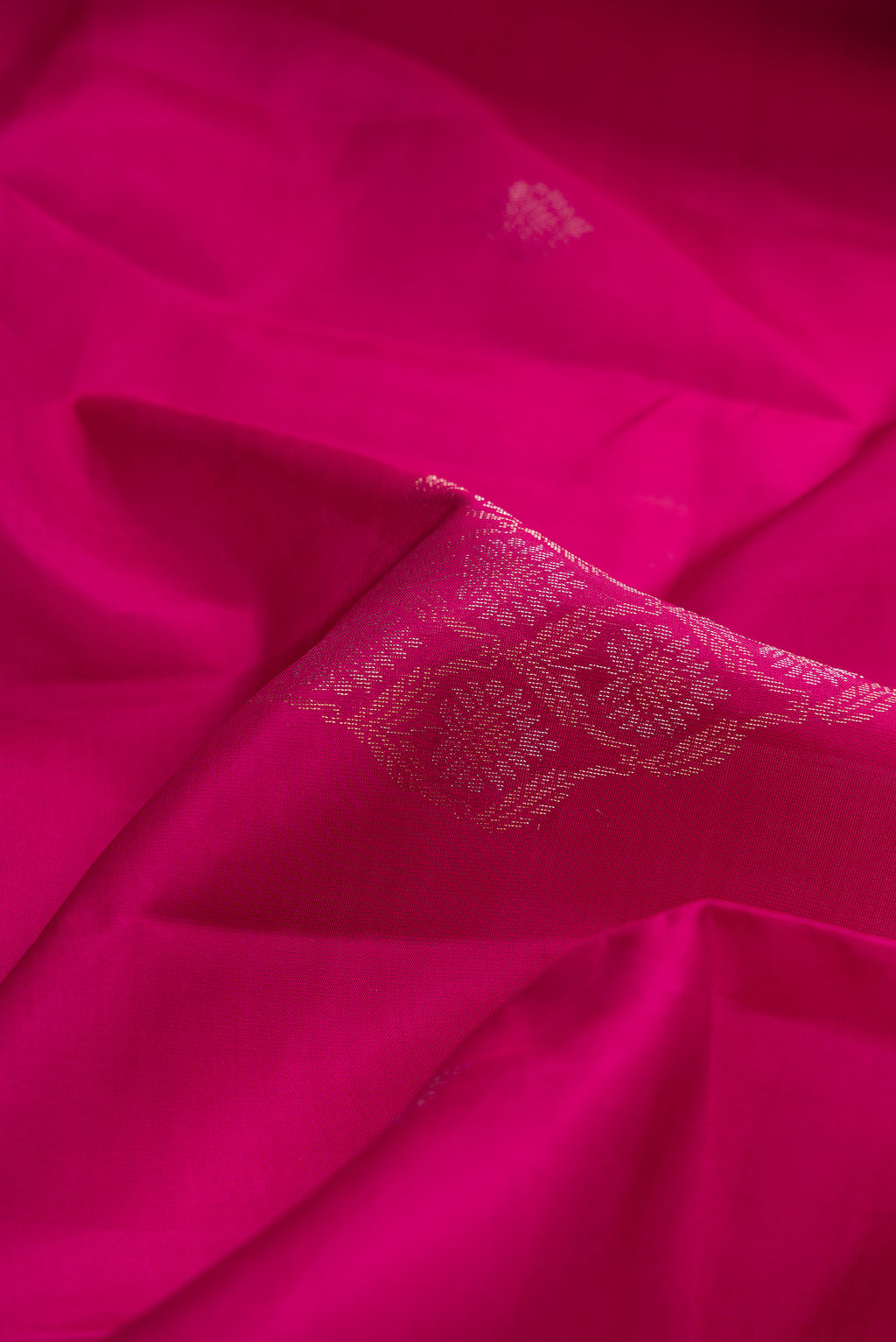 Close up of Magenta Dual Tone Soft Silk Saree with Zari Butta on the body and Without Border.  displaying folds