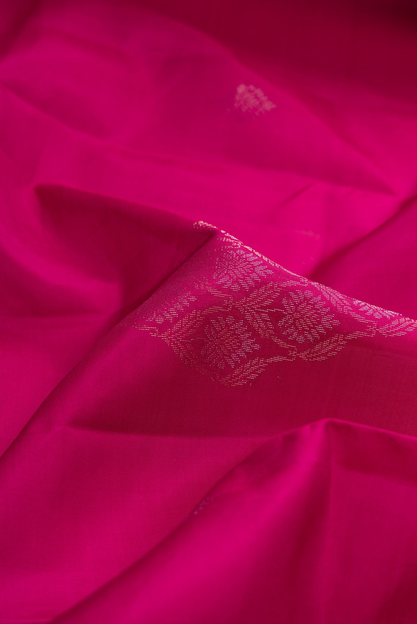 Close up of Magenta Dual Tone Soft Silk Saree with Zari Butta on the body and Without Border.  displaying folds