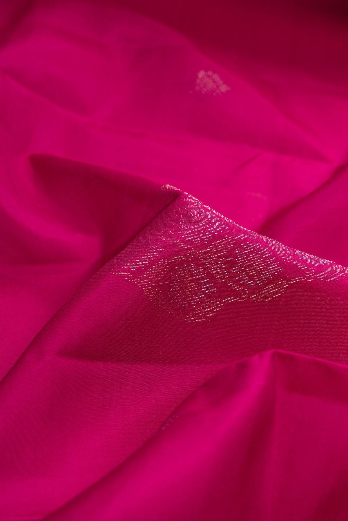Close up of Magenta Dual Tone Soft Silk Saree with Zari Butta on the body and Without Border.  displaying folds