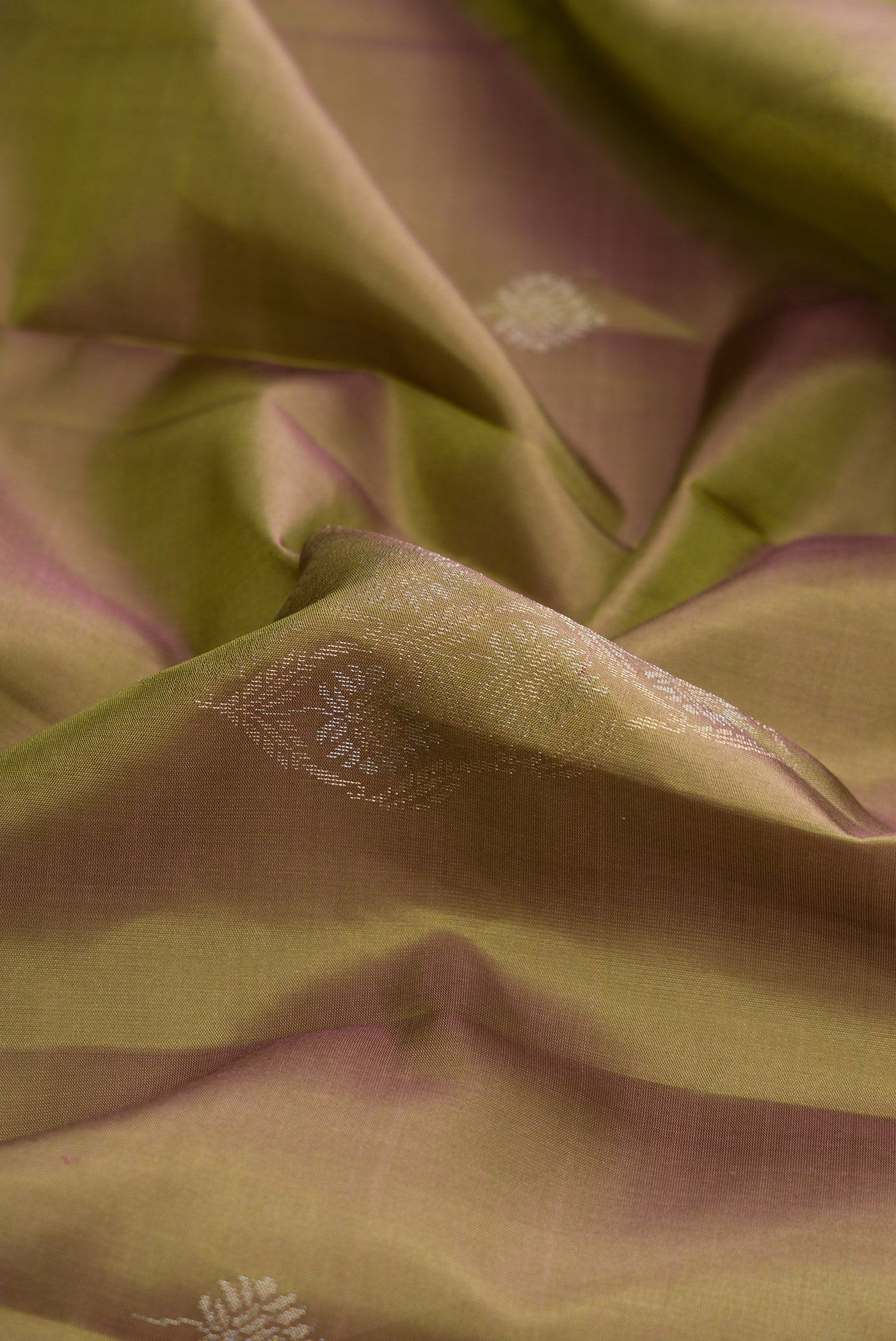 Close up of Green Dual Tone Soft Silk Saree with Zari Butta on the body and Without Border.  displaying folds