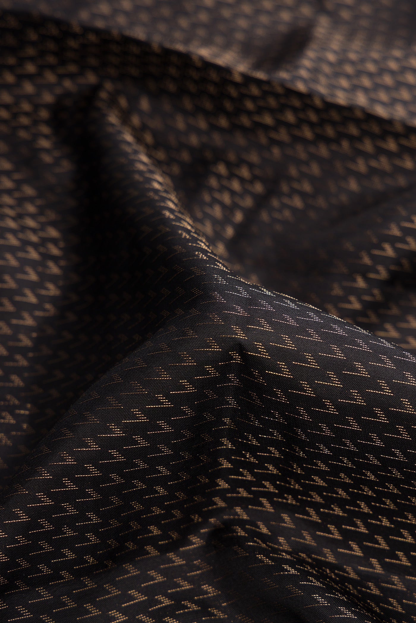 Close up of Black Dual Tone Soft Silk Saree with Zari Brocade on the body and Fancy Border.  displaying folds