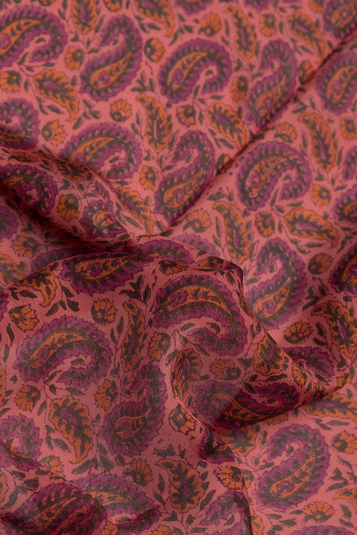 Close up of Golden Peach Dual Tone Crepe Saree with Printed design on the body and Zari Border.  displaying folds