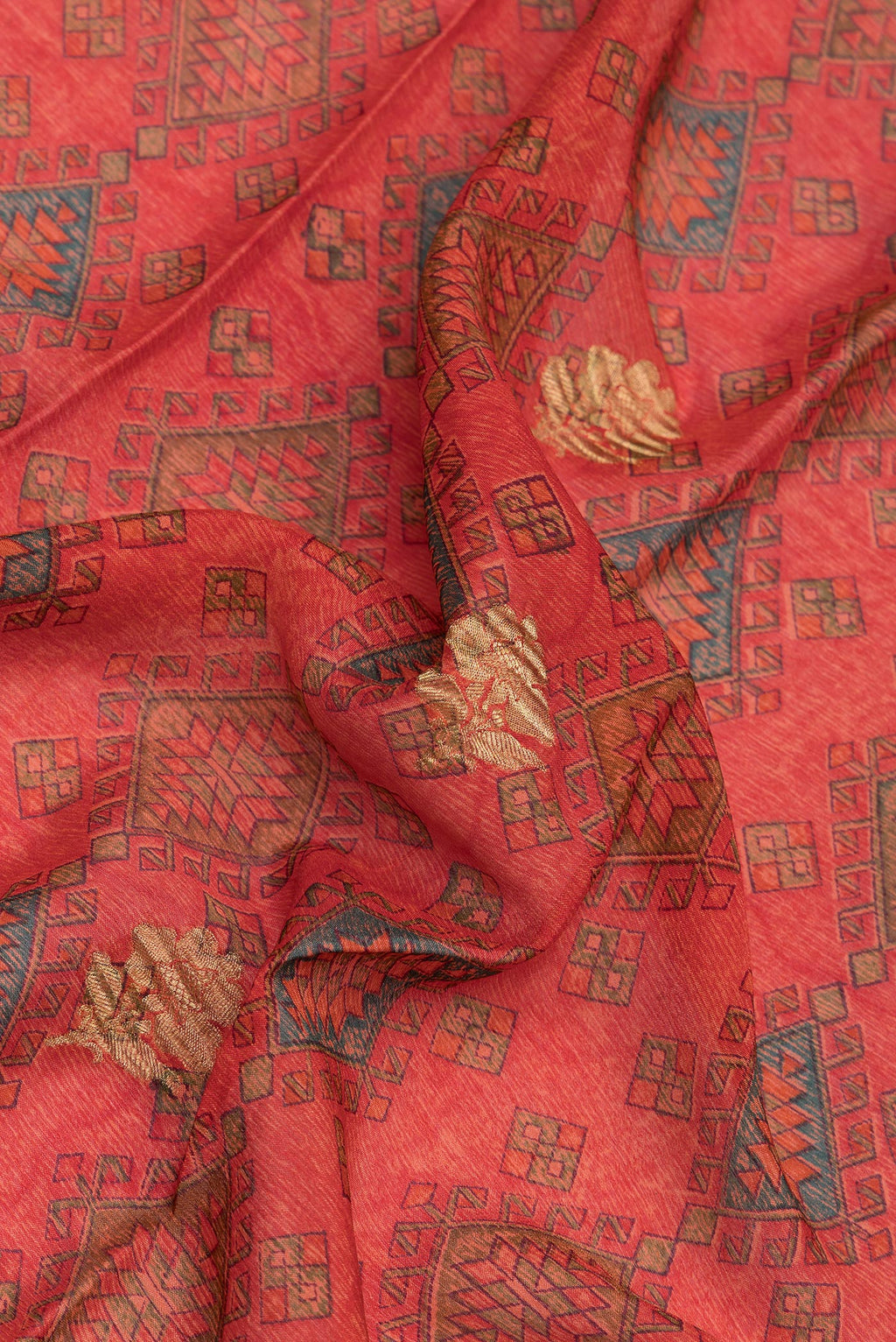 Close up of Orange Crepe Saree with Printed design on the body and Zari Border.  displaying folds