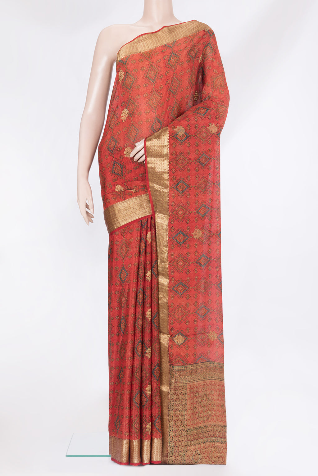 Orange Crepe Saree with Printed design on the body and Zari Border.  displayed on a mannequin