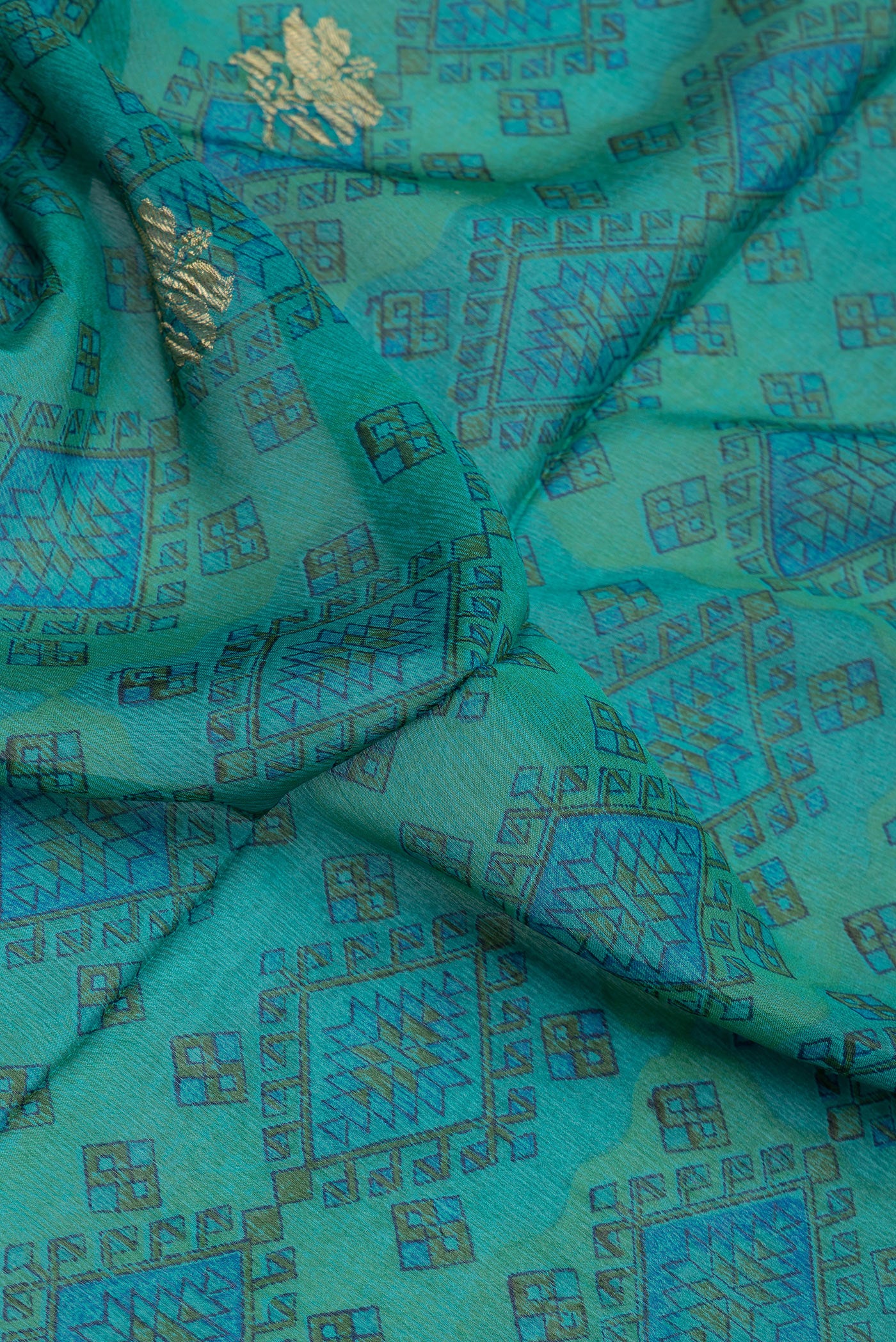 Close up of Peacock Blue Dual Tone Crepe Saree with Printed design on the body and Zari Border.  displaying folds