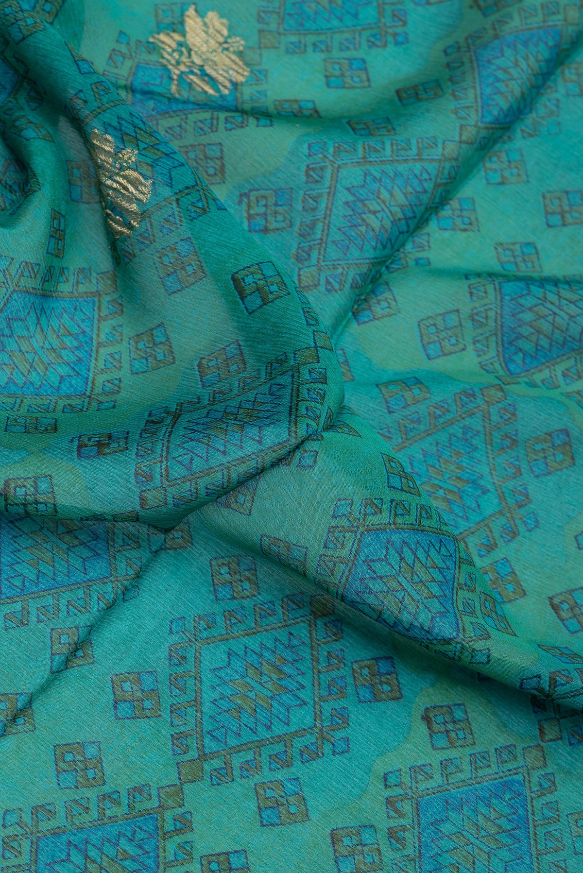 Close up of Peacock Blue Dual Tone Crepe Saree with Printed design on the body and Zari Border.  displaying folds