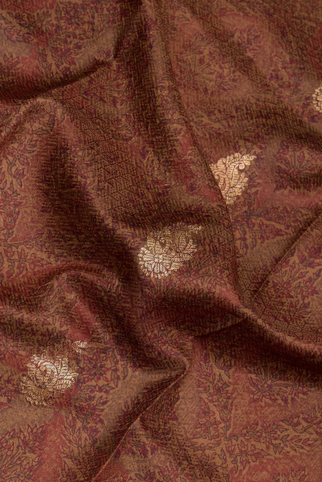 Close up of Brown Kanchipuram Silk Saree with Printed design on the body and Zari Border.  displaying folds