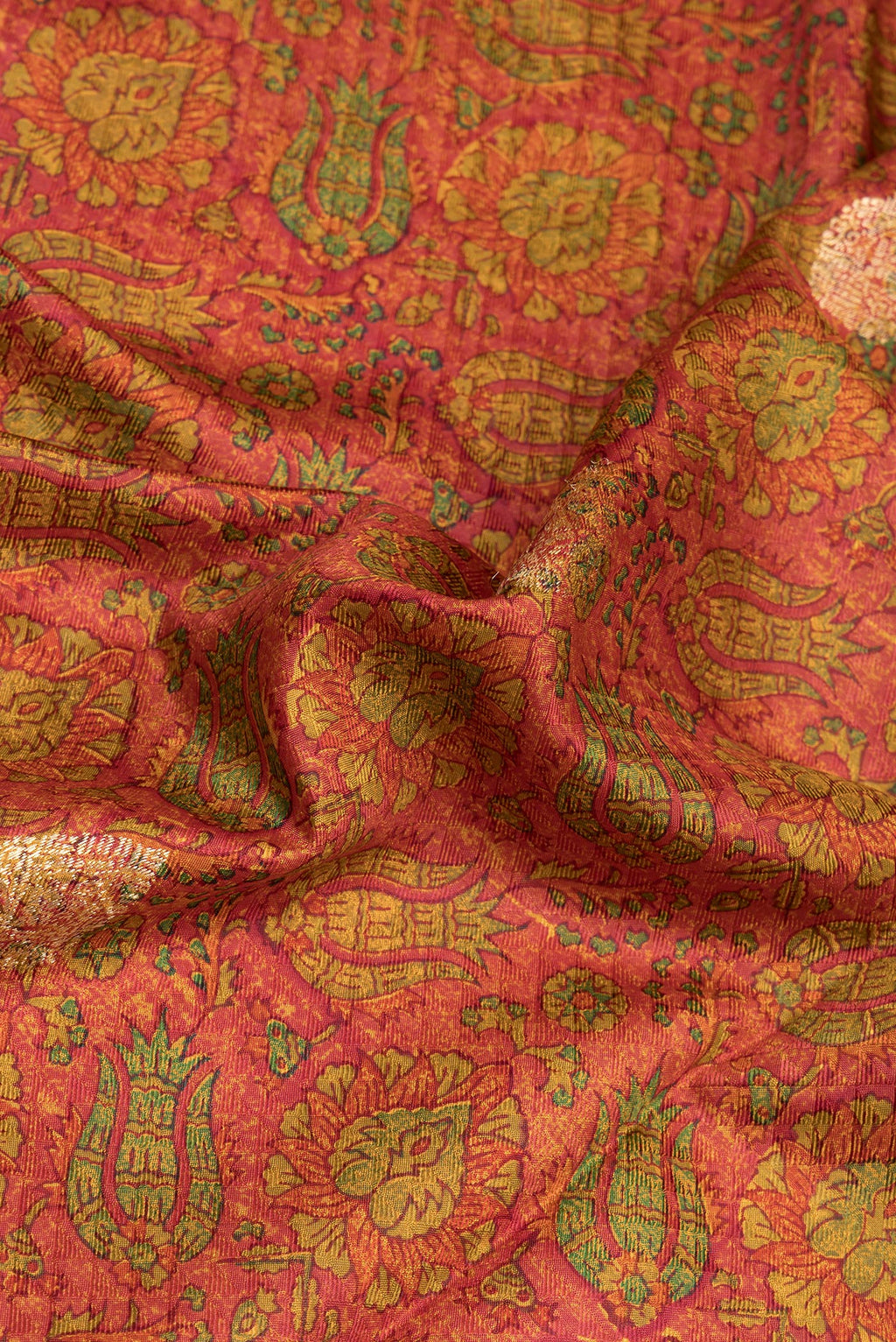 Close up of Orange Kanchipuram Silk Saree with Printed design on the body and Zari Border.  displaying folds