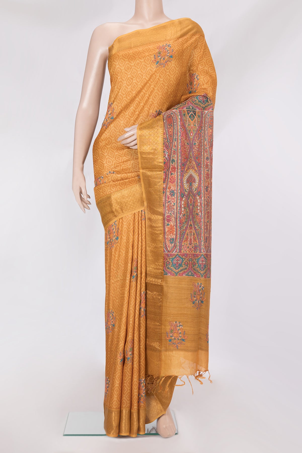 Mustard Tussar Silk Saree with Embroidery on the body and Zari Border.  displayed on a mannequin