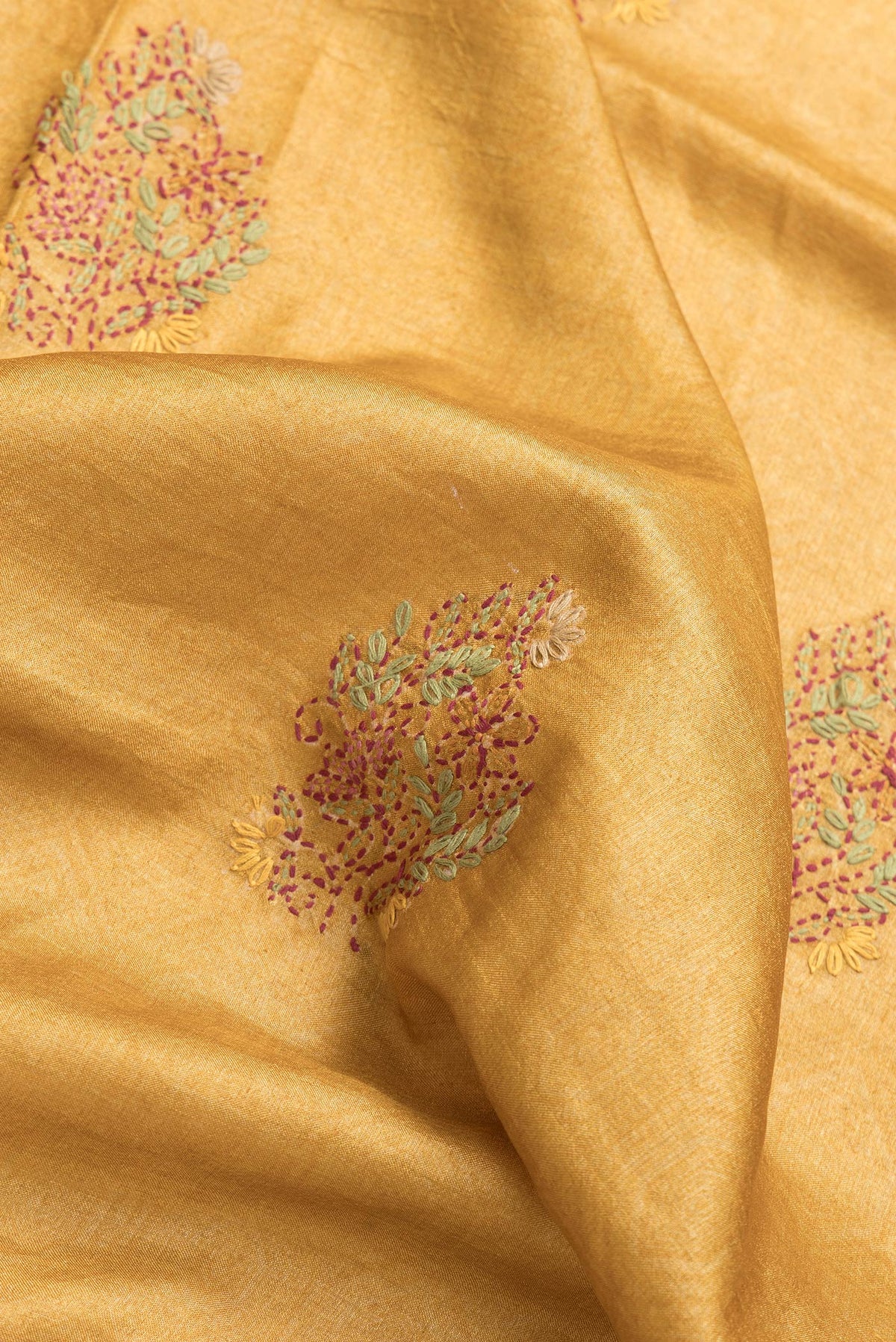 Close up of Mustard Dual Tone Tussar Silk Saree with Embroidery on the body and Zari Border.  displaying folds