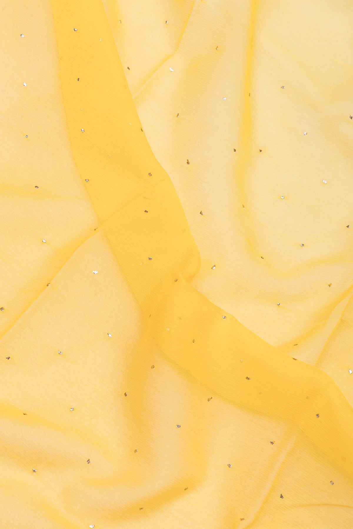 Close up of Yellow Chiffon Saree with Embroidery on the body and Zari Border.  displaying folds