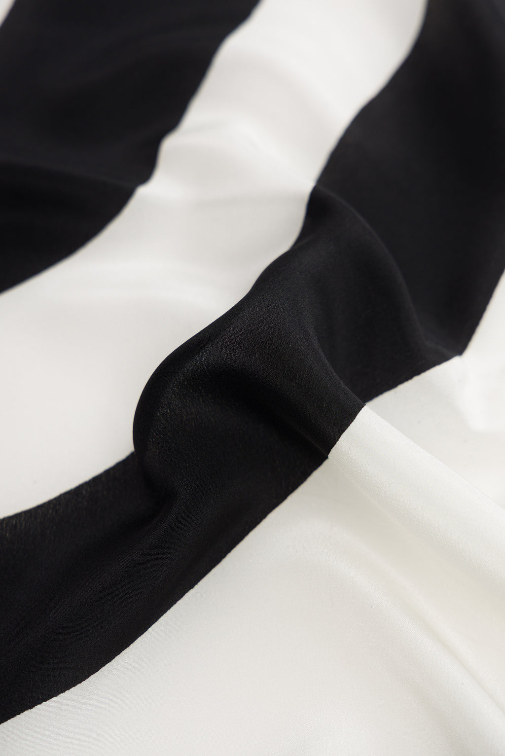 Close up of Off White Dual Tone Mysore Crepe Saree with Printed design on the body and Without Border.  displaying folds