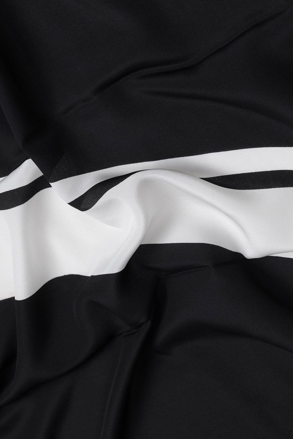 Close up of Black Dual Tone Mysore Crepe Saree with Printed design on the body and Plain Border.  displaying folds