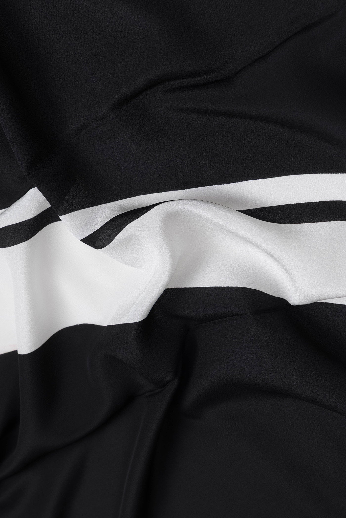 Close up of Black Dual Tone Mysore Crepe Saree with Printed design on the body and Plain Border.  displaying folds