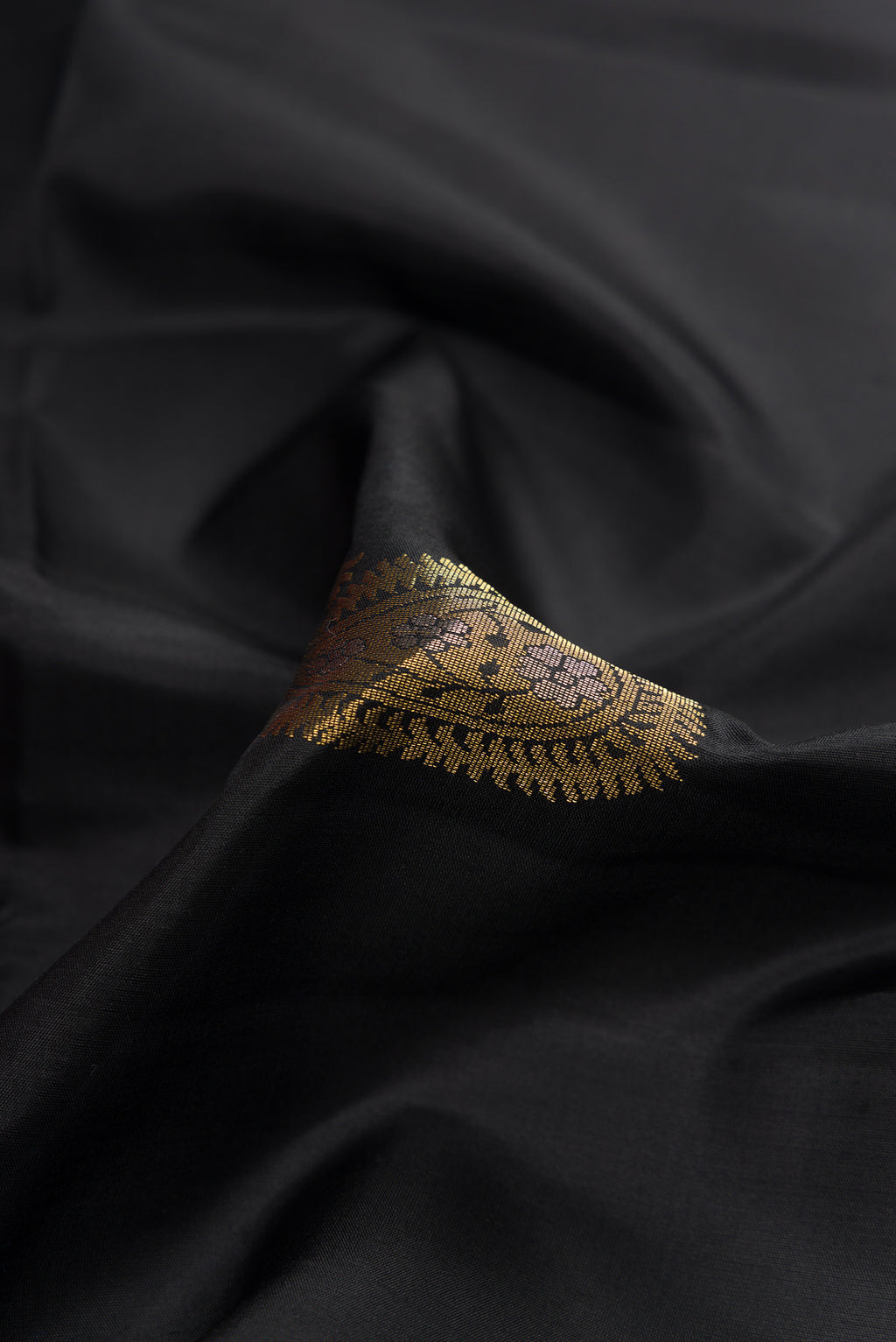 Close up of Black Dual Tone Soft Silk Saree with Zari Butta on the body and Zari Border.  displaying folds