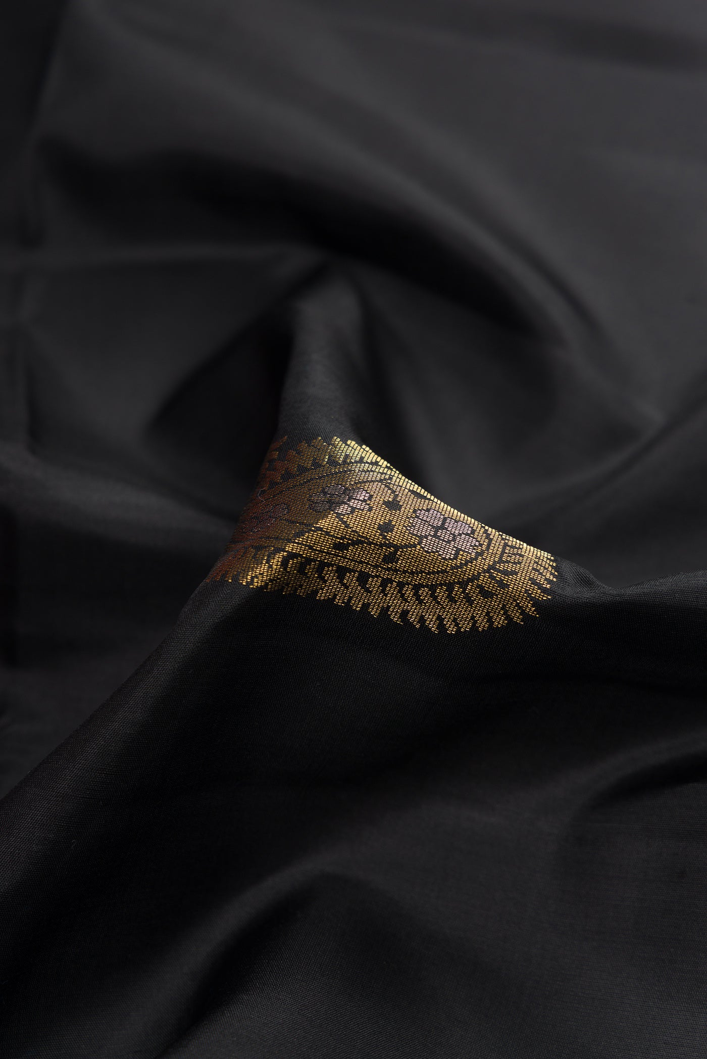 Close up of Black Dual Tone Soft Silk Saree with Zari Butta on the body and Zari Border.  displaying folds