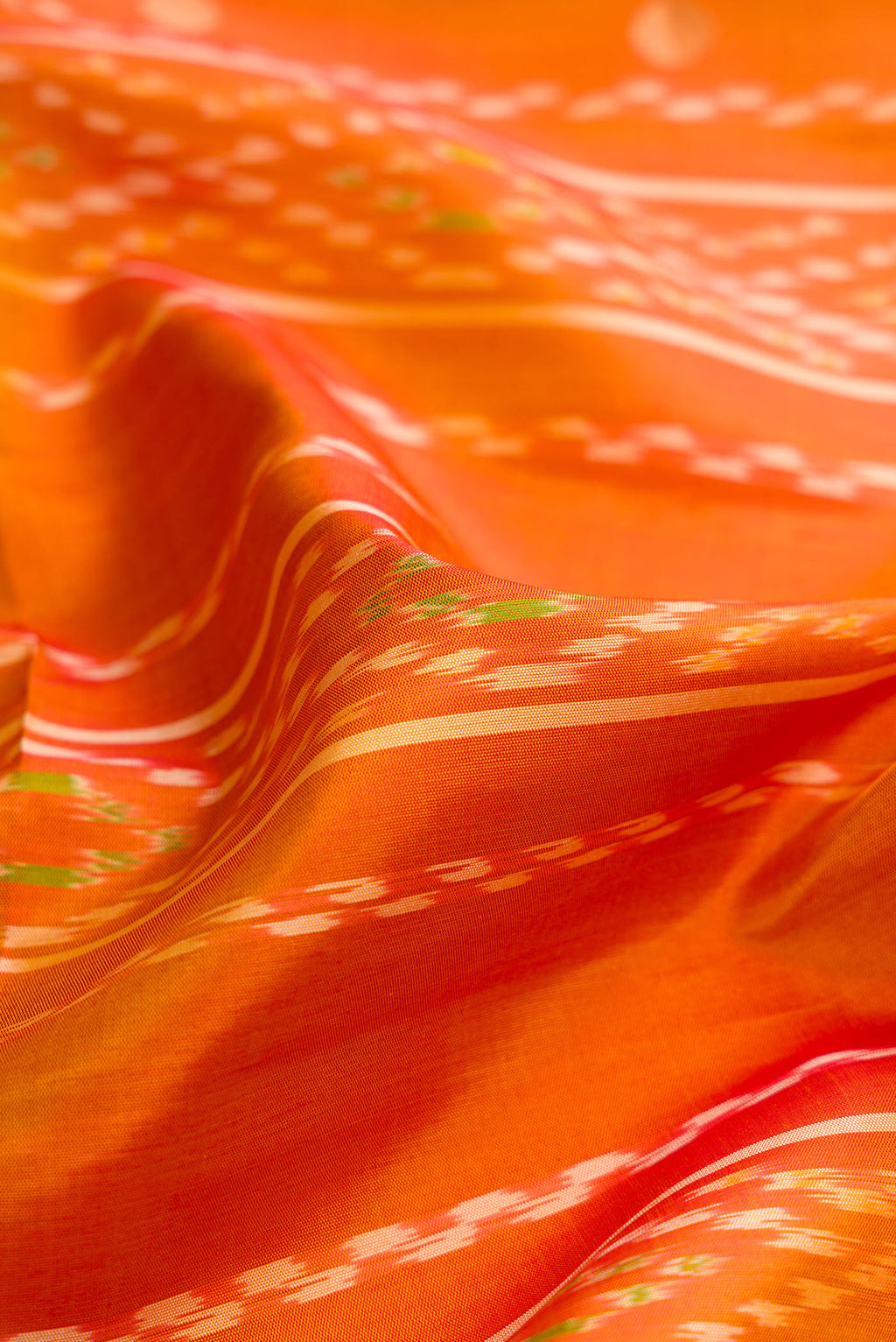 Close up of Mustard Dual Tone Soft Silk Saree with Ikat Print on the body and Zari Border.  displaying folds
