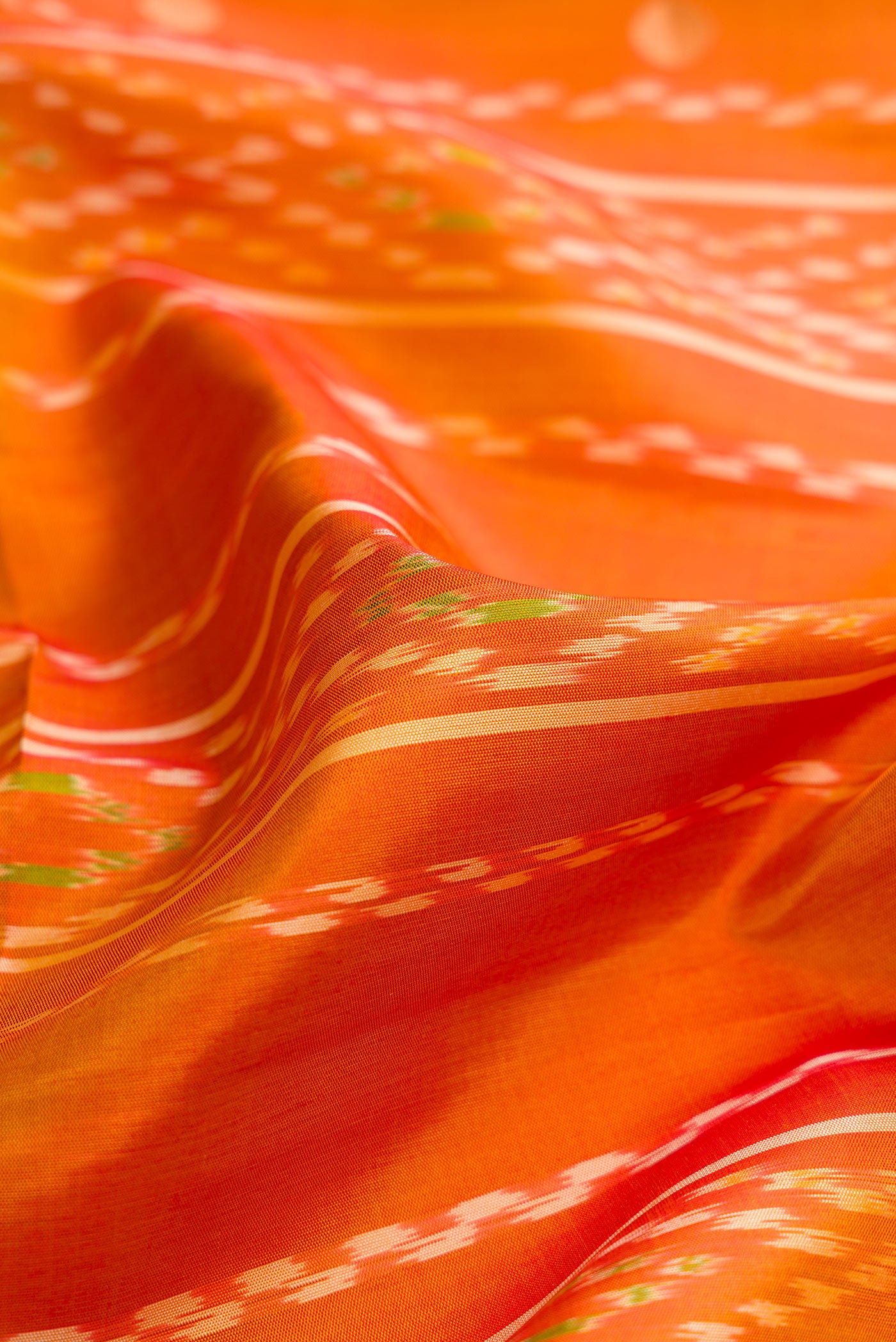 Close up of Mustard Dual Tone Soft Silk Saree with Ikat Print on the body and Zari Border.  displaying folds