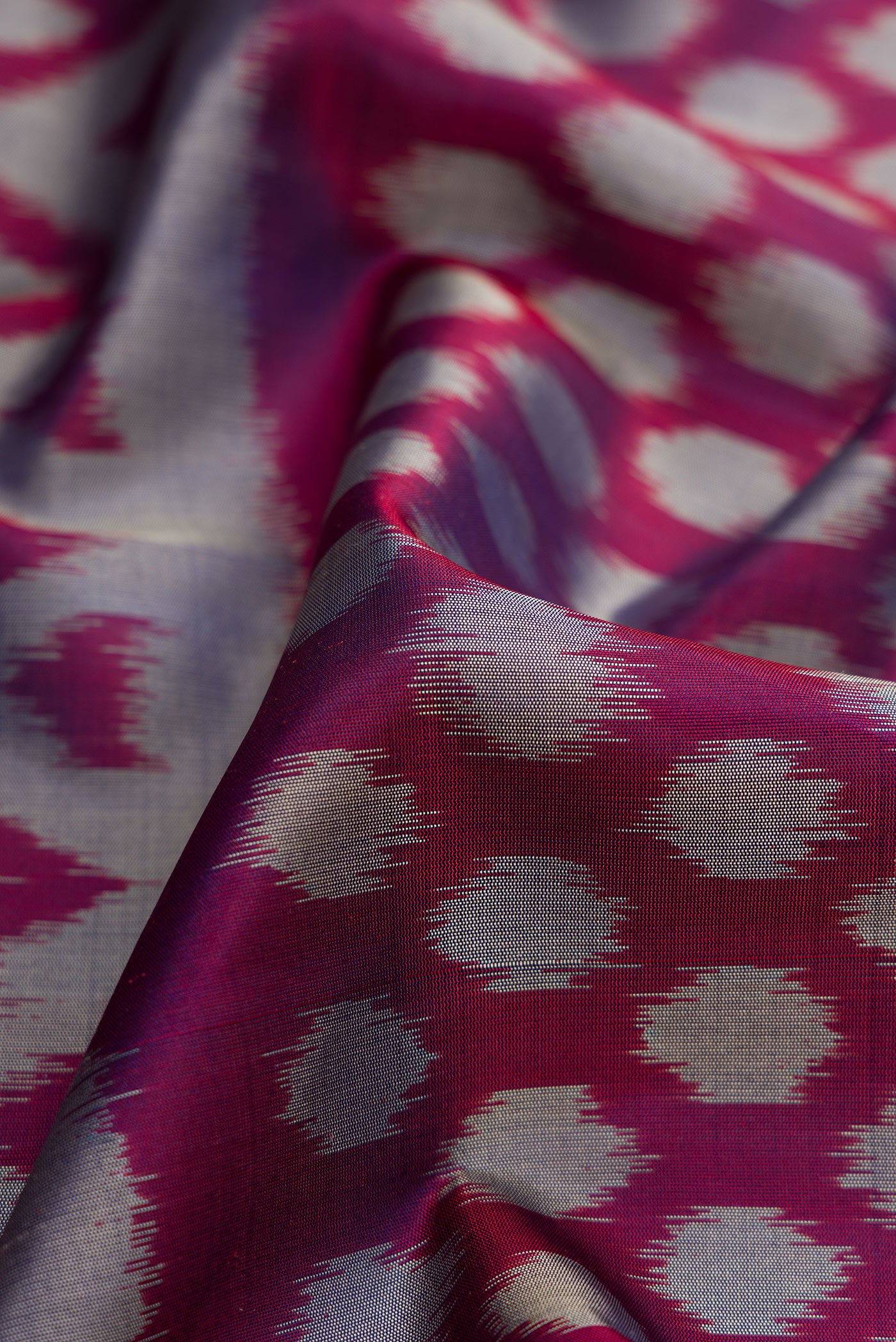 Close up of Navy Blue Dual Tone Soft Silk Saree with Ikat Print on the body and Zari Border.  displaying folds