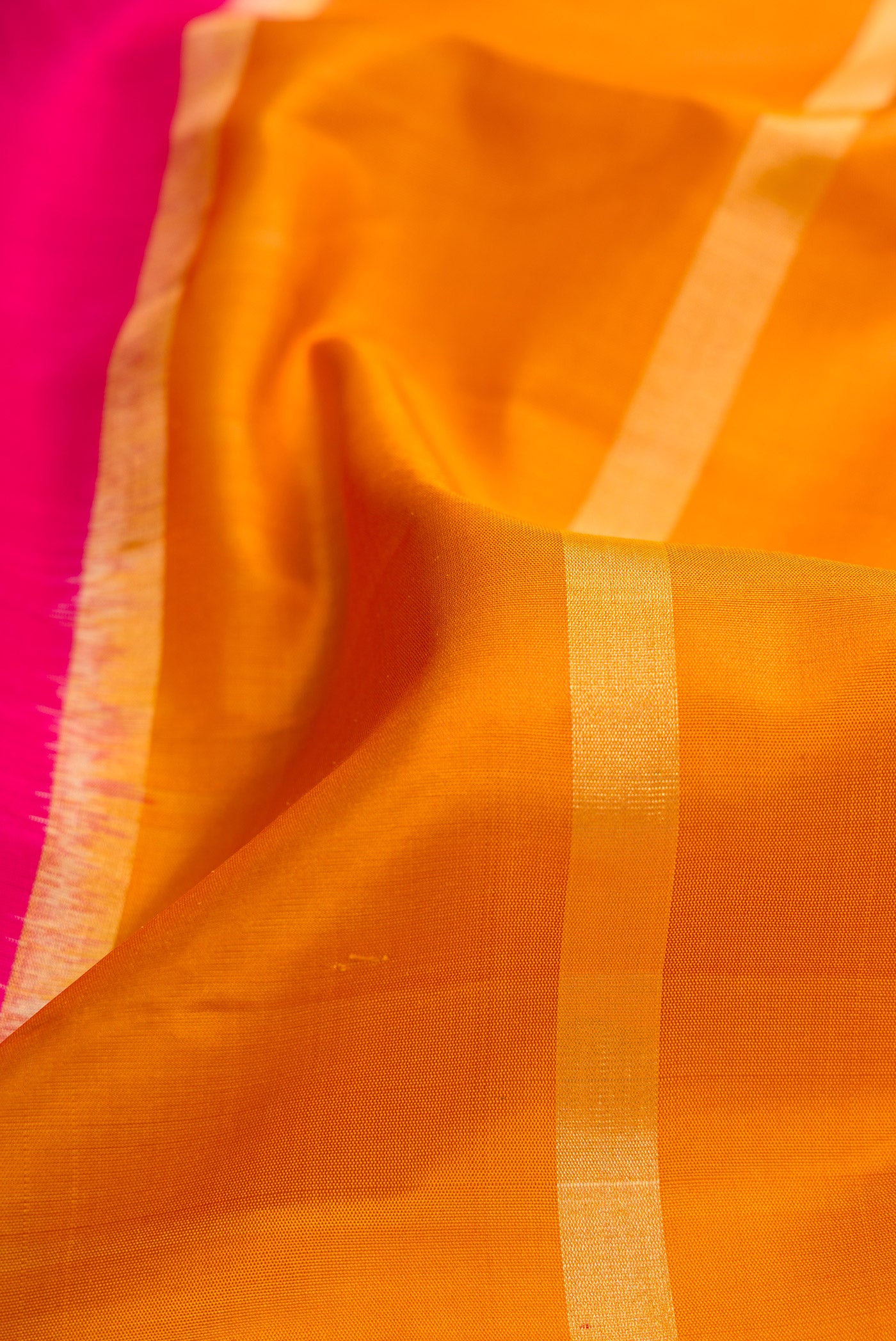 Close up of Mustard Dual Tone Soft Silk Saree with Stripes on the body and Ikat Border.  displaying folds