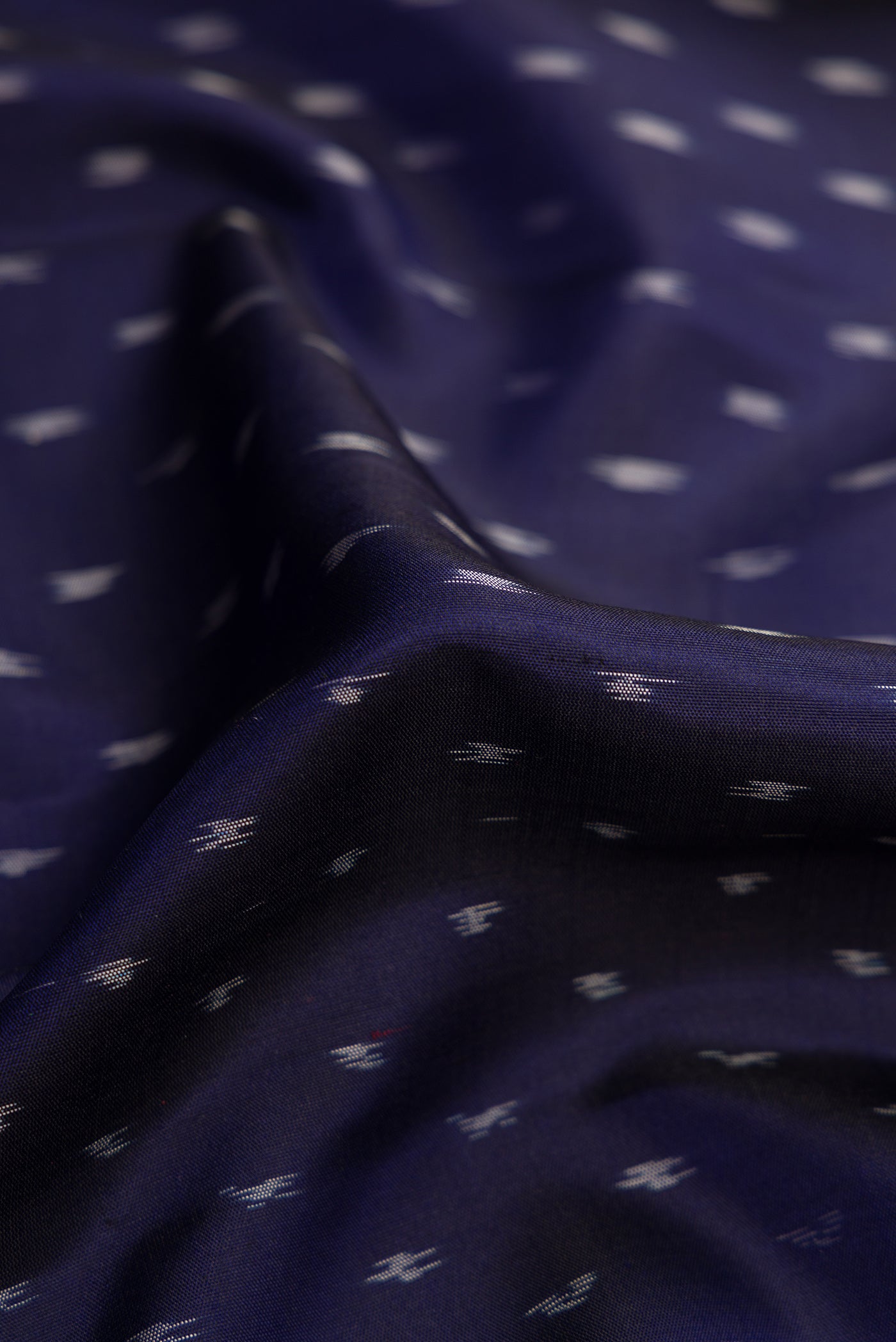 Close up of Navy Blue Dual Tone Soft Silk Saree with Ikat Print on the body and Ikat Border.  displaying folds
