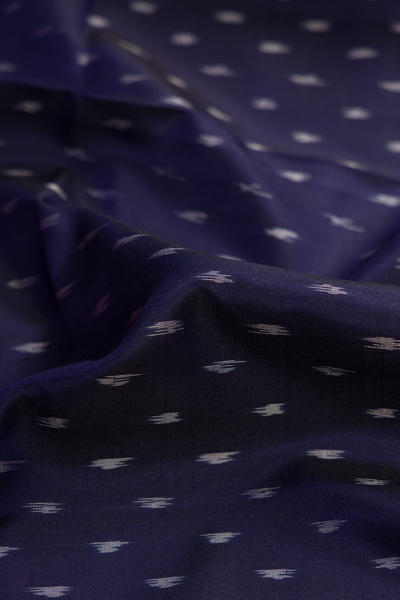 Close up of Navy Blue Dual Tone Soft Silk Saree with Ikat Print on the body and Ikat Border.  displaying folds