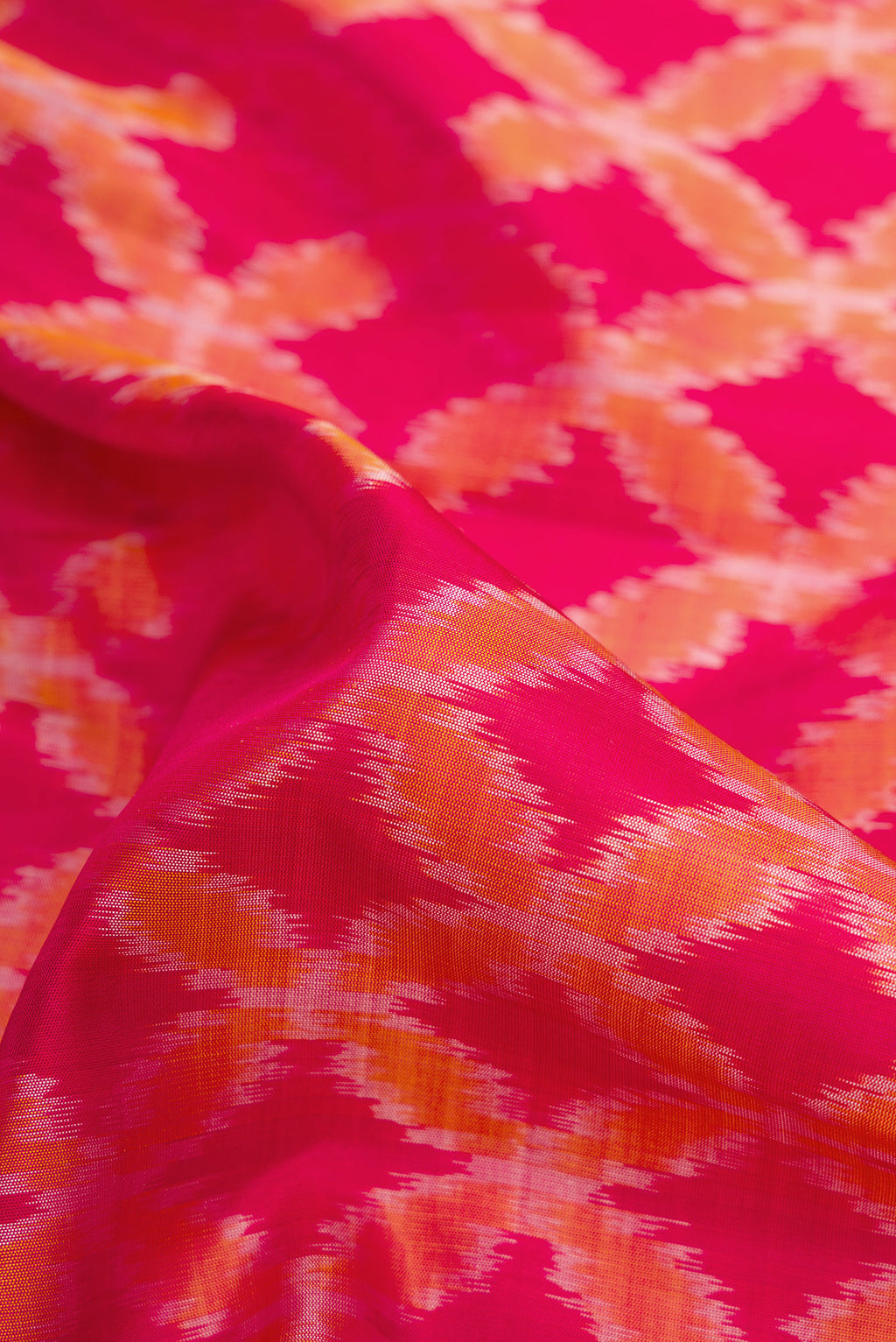 Close up of Dark Pink Dual Tone Soft Silk Saree with Ikat Print on the body and Zari Border.  displaying folds
