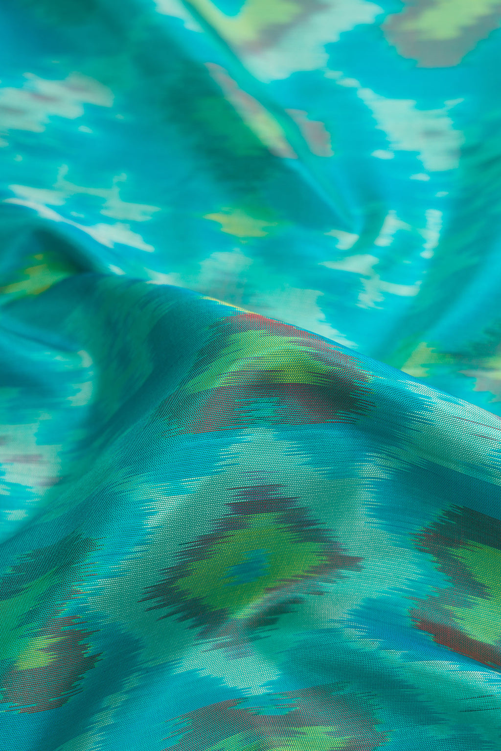 Close up of Sky Blue Dual Tone Soft Silk Saree with Ikat Print on the body and Zari Border.  displaying folds