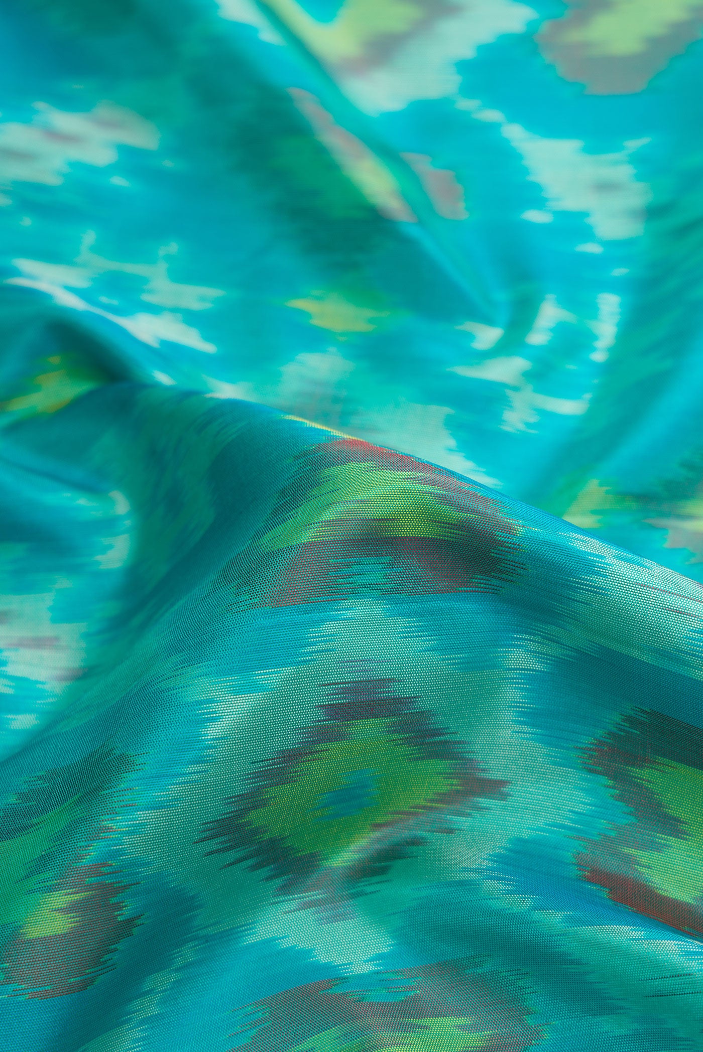 Close up of Sky Blue Dual Tone Soft Silk Saree with Ikat Print on the body and Zari Border.  displaying folds