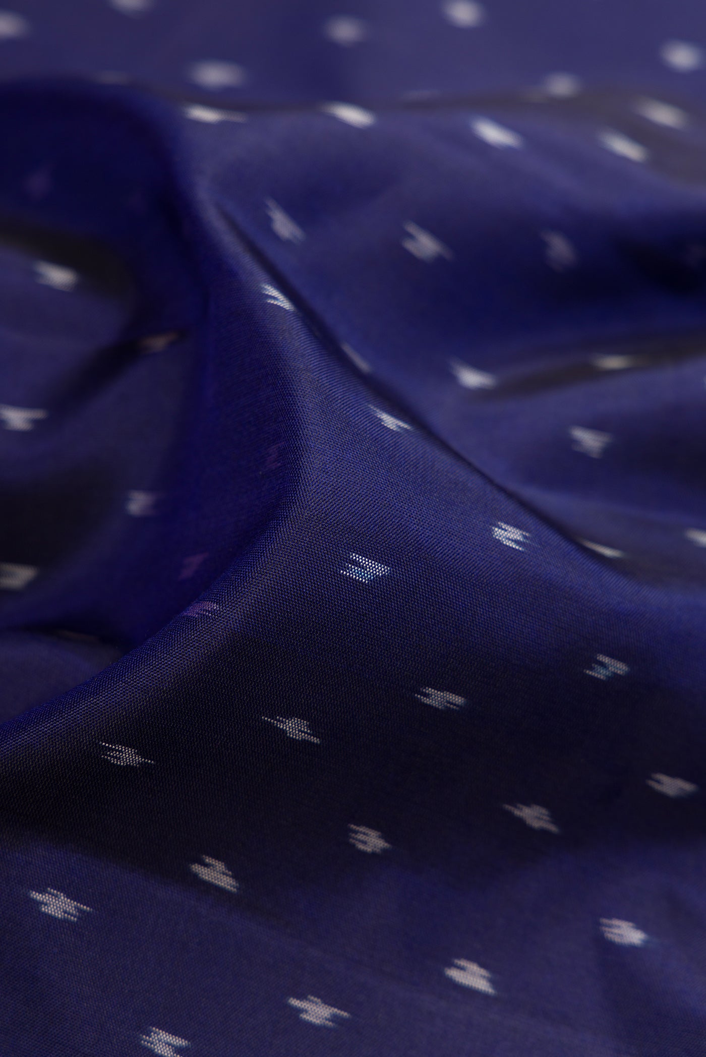 Close up of Navy Blue Dual Tone Soft Silk Saree with Ikat Print on the body and Fancy Border.  displaying folds