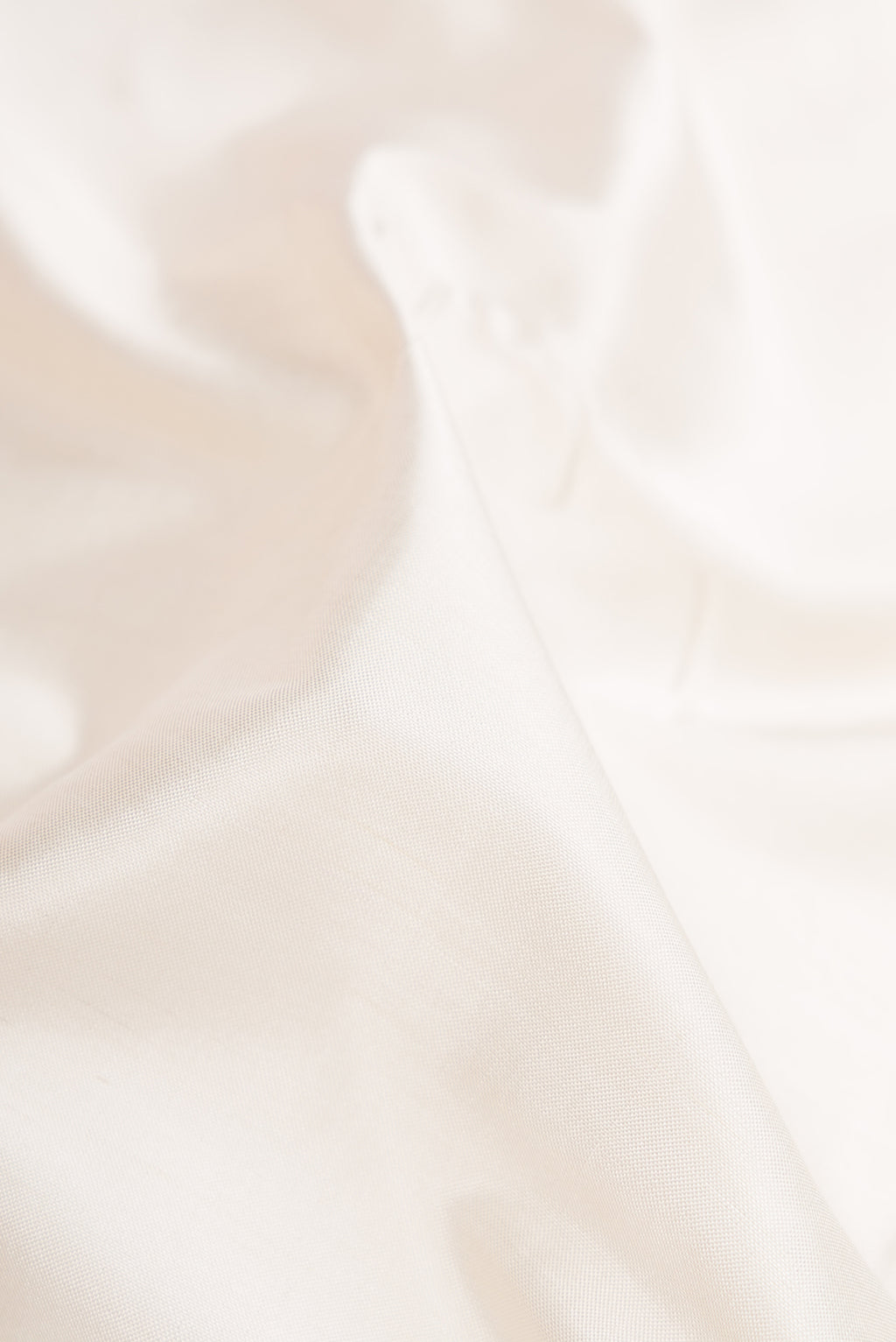 Close up of White Dual Tone Double Ikat Saree with Ikat Print on the body and Zari Border.  displaying folds