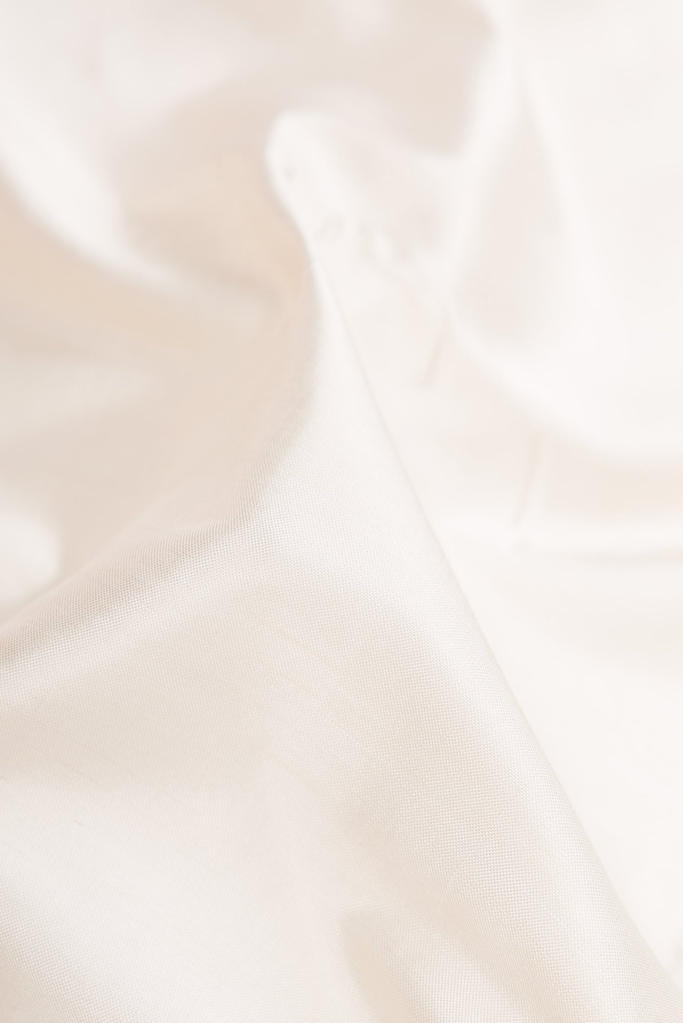 Close up of White Dual Tone Double Ikat Saree with Ikat Print on the body and Zari Border.  displaying folds