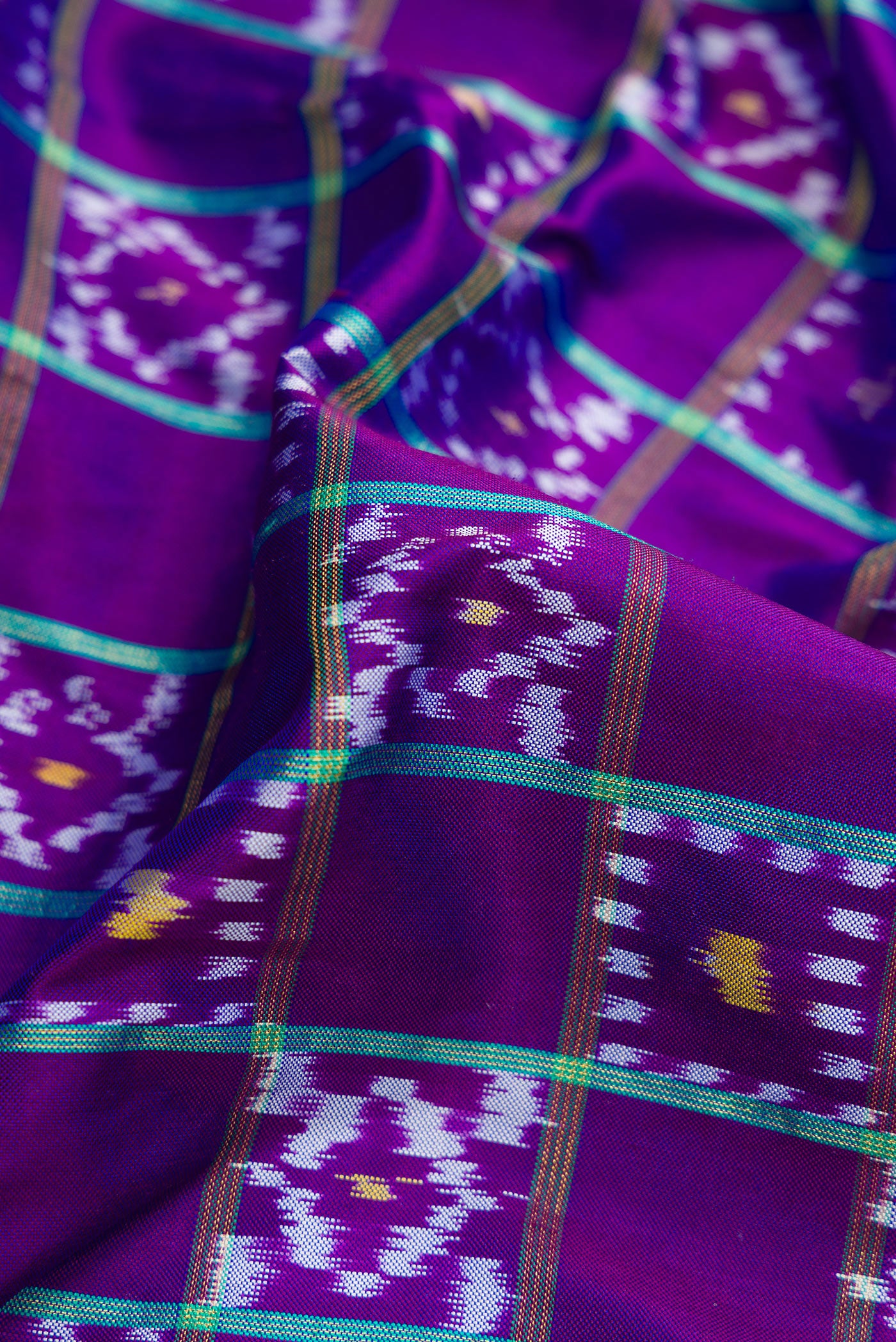 Close up of Purple Dual Tone Double Ikat Saree with Ikat Print on the body and Ikat Border.  displaying folds