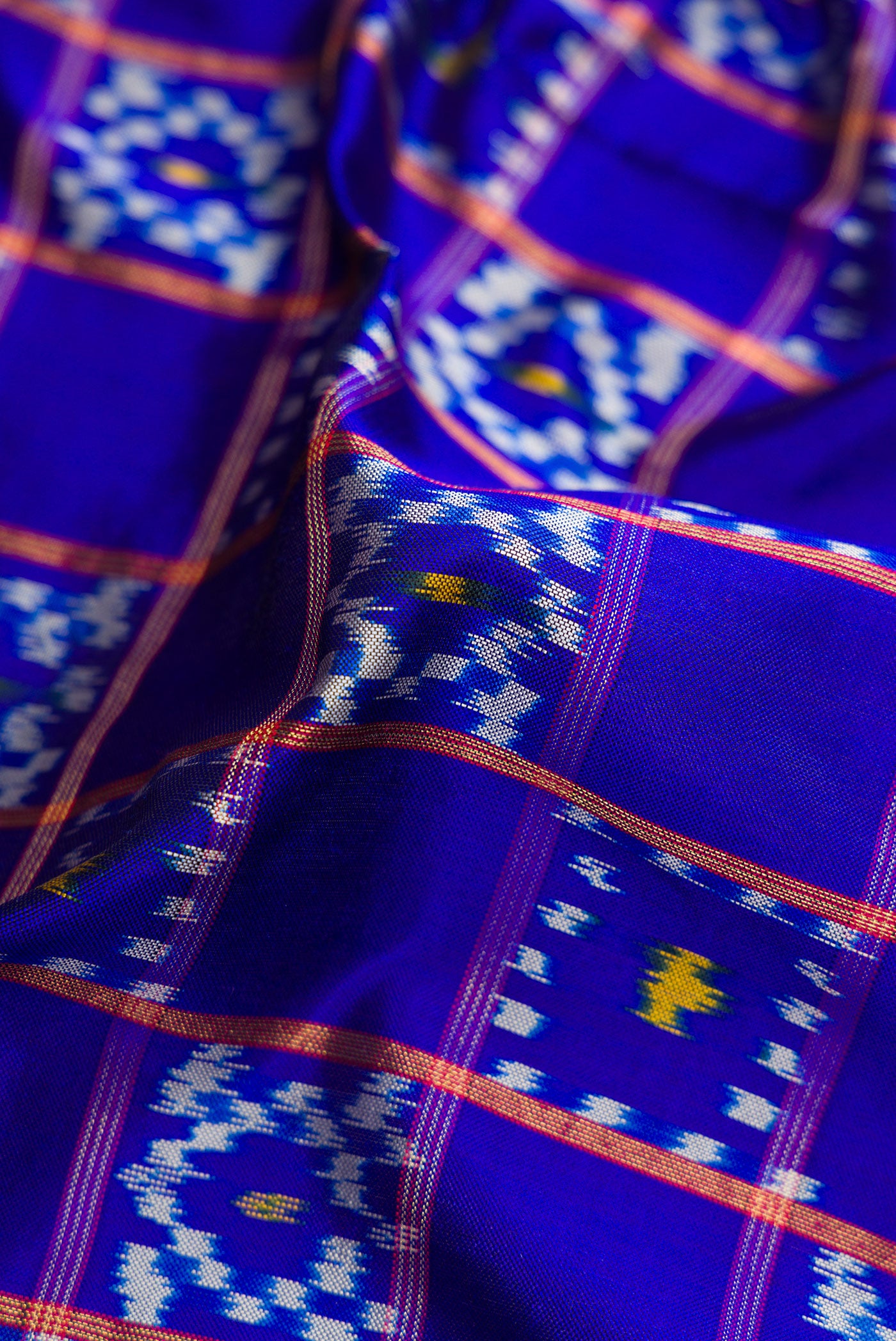 Close up of Navy Blue Dual Tone Double Ikat Saree with Ikat Print on the body and Ikat Border.  displaying folds
