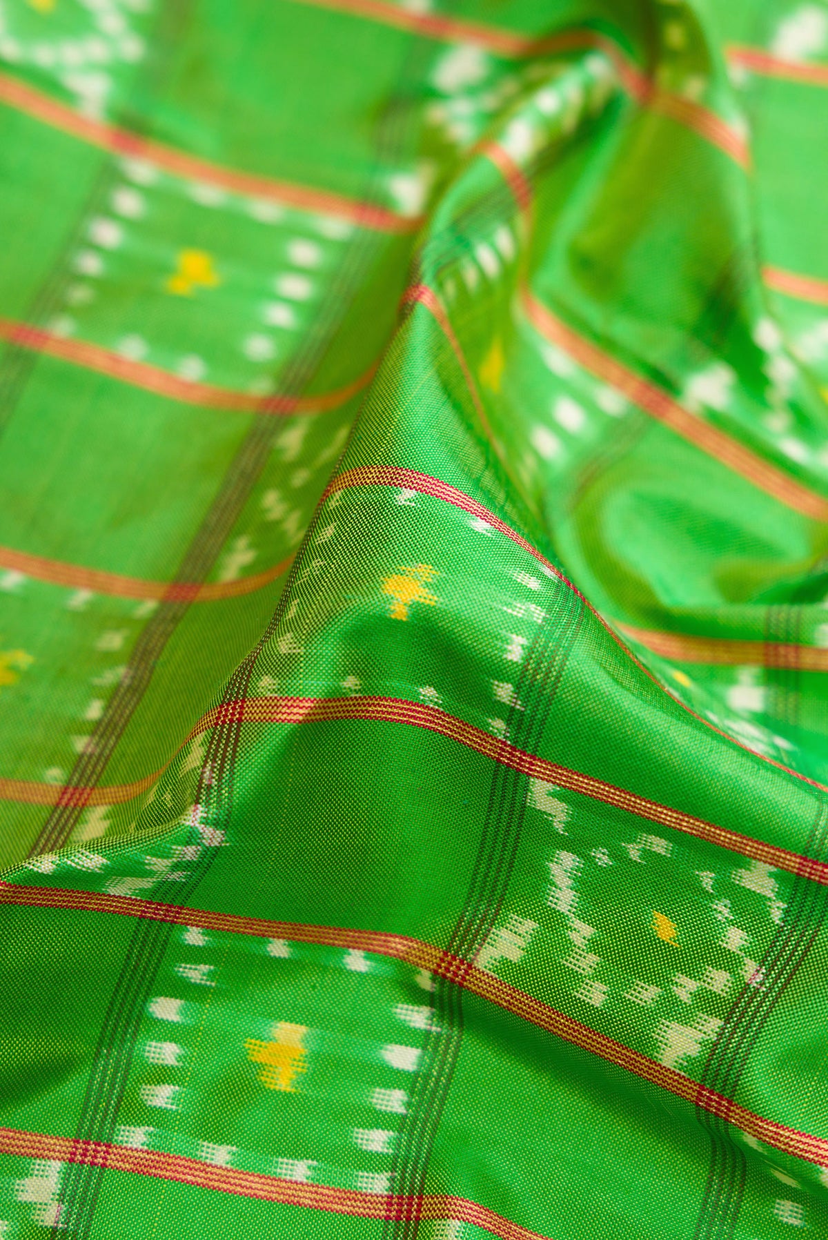 Close up of Parrot Green Dual Tone Double Ikat Saree with Ikat Print on the body and Ikat Border.  displaying folds