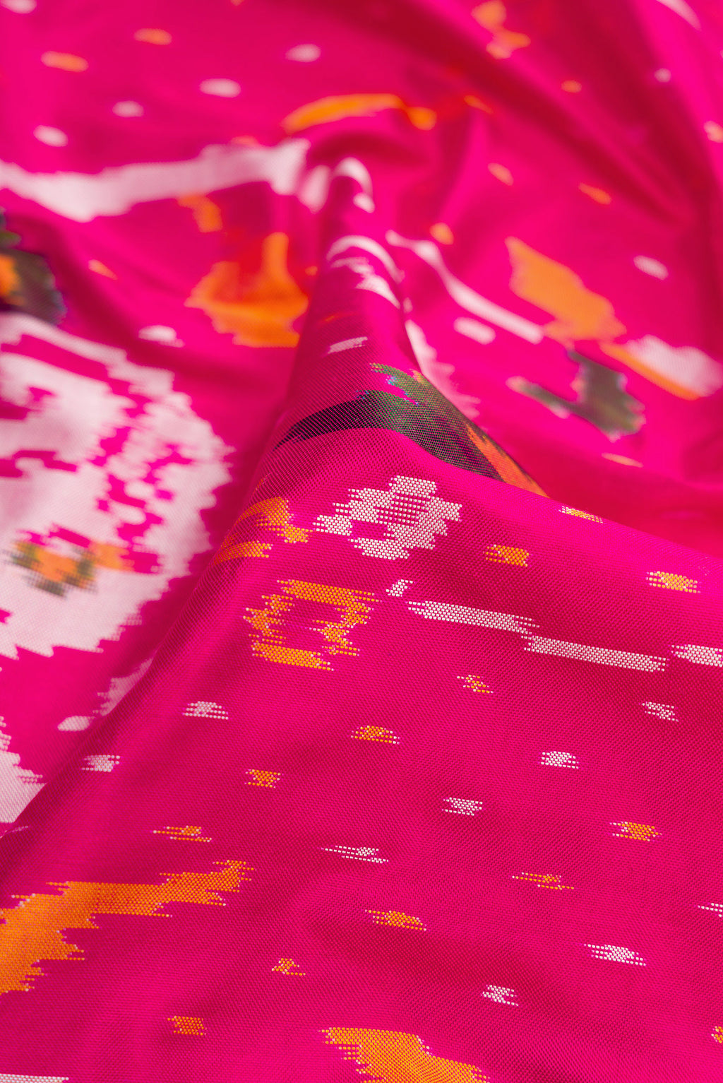 Close up of Pink Dual Tone Double Ikat Saree with Ikat Print on the body and Ikat Border.  displaying folds