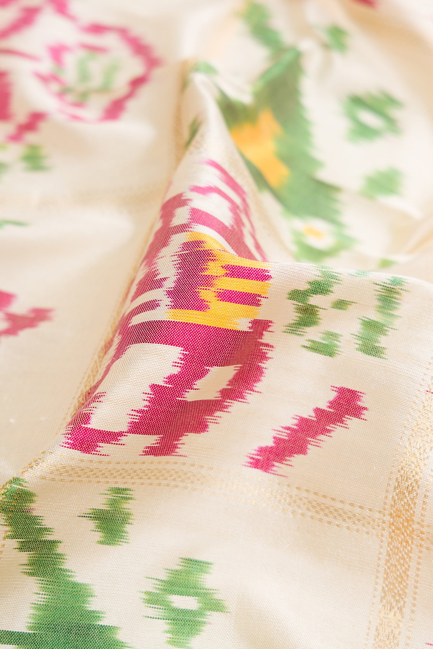 Close up of Off White Dual Tone Double Ikat Saree with Ikat Print on the body and Zari Border.  displaying folds