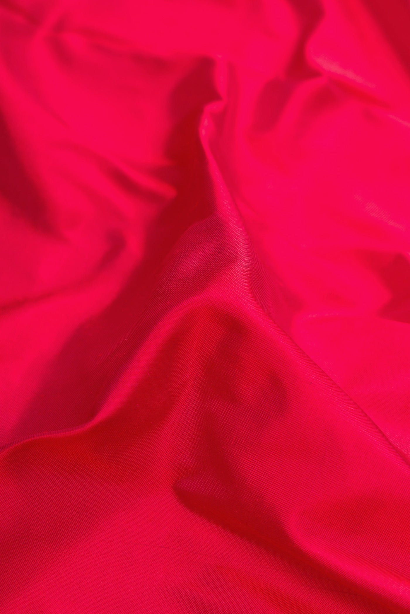 Close up of Pink Dual Tone Double Ikat Saree with Plain Body and Zari Border.  displaying folds