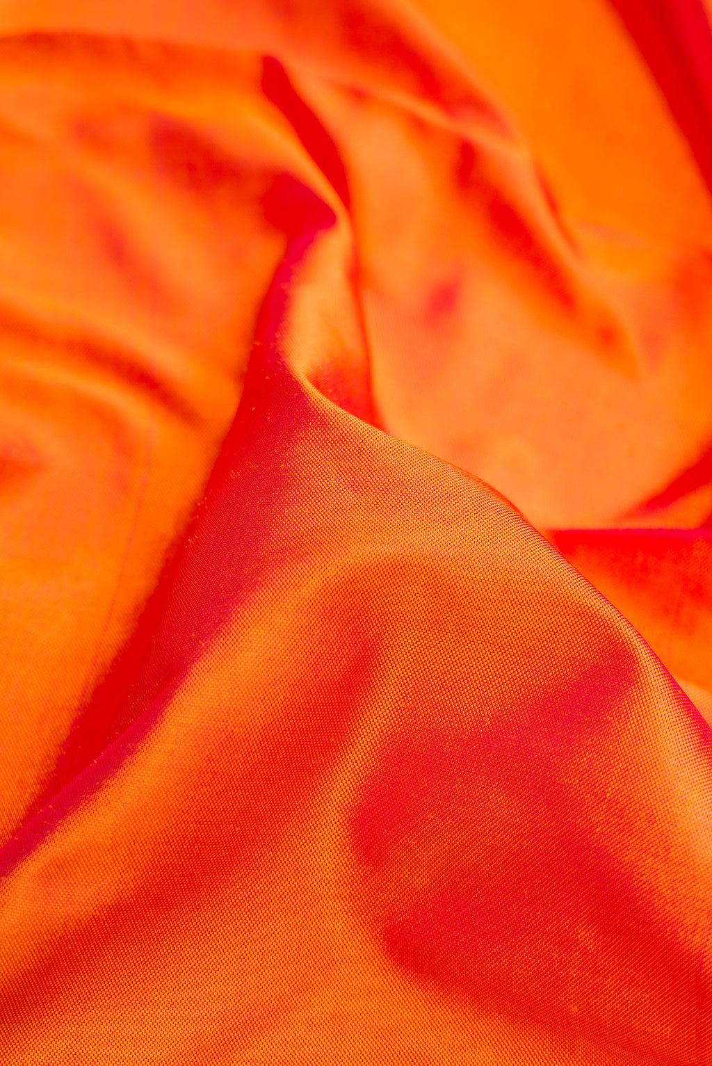 Close up of Coral Dual Tone Double Ikat Saree with Ikat Print on the body and Fancy Border.  displaying folds