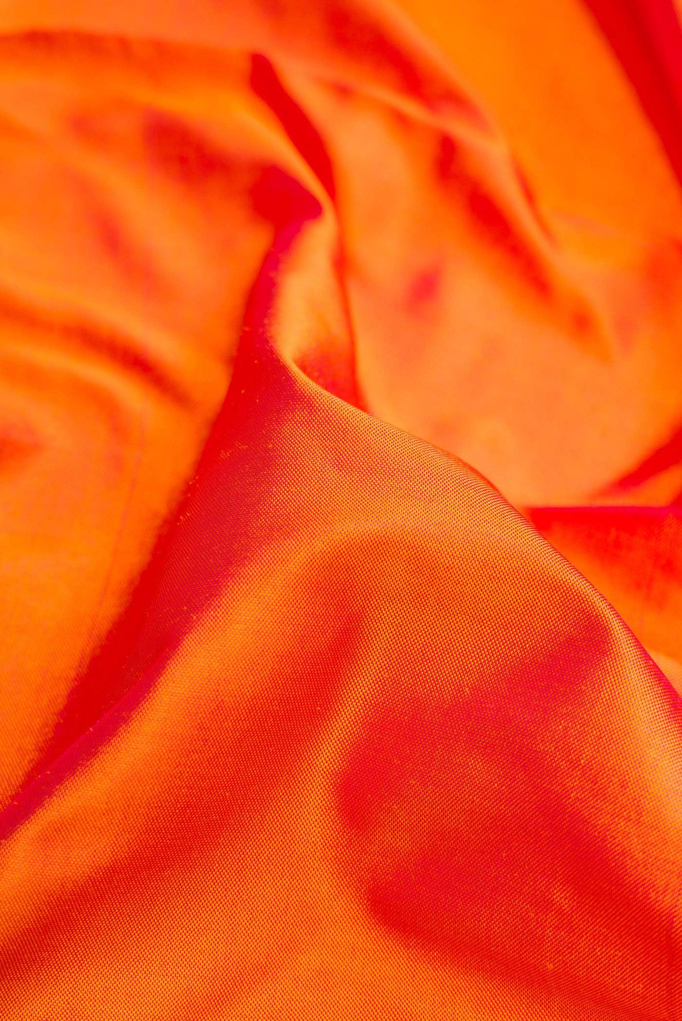 Close up of Coral Dual Tone Double Ikat Saree with Ikat Print on the body and Fancy Border.  displaying folds