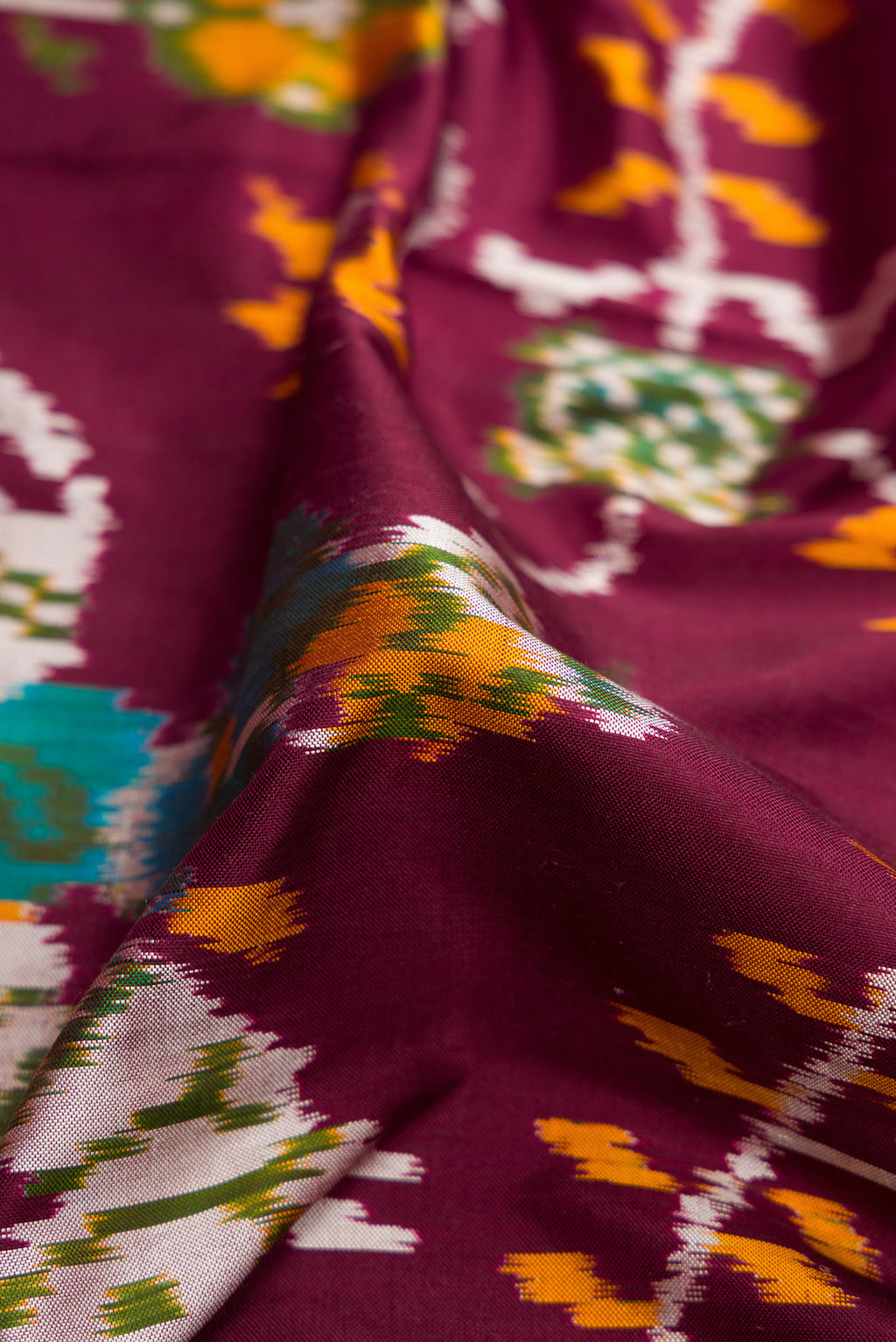Close up of Coffee Brown Dual Tone Double Ikat Saree with Ikat Print on the body and Zari Border.  displaying folds