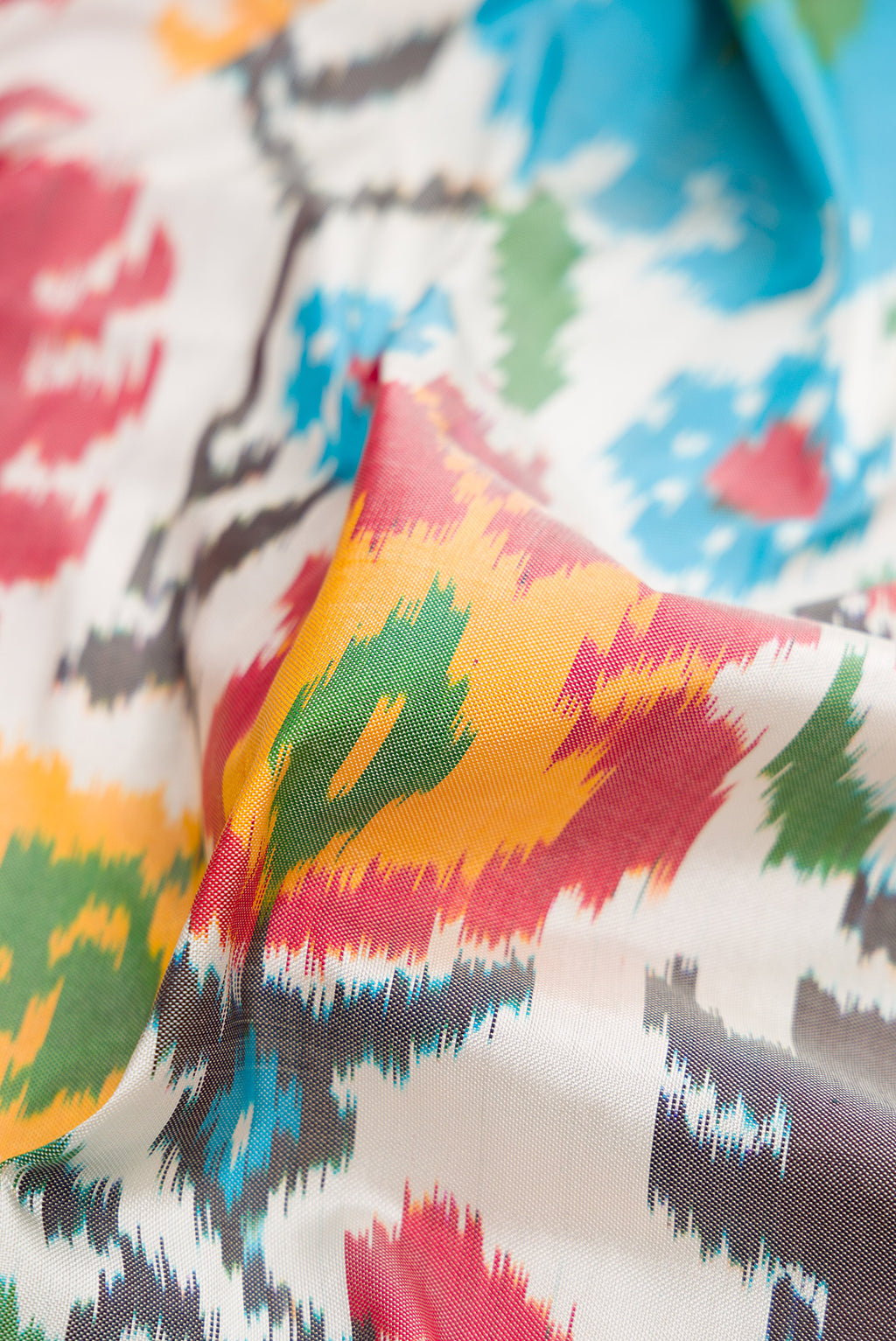 Close up of White Dual Tone Double Ikat Saree with Ikat Print on the body and Thread Border.  displaying folds