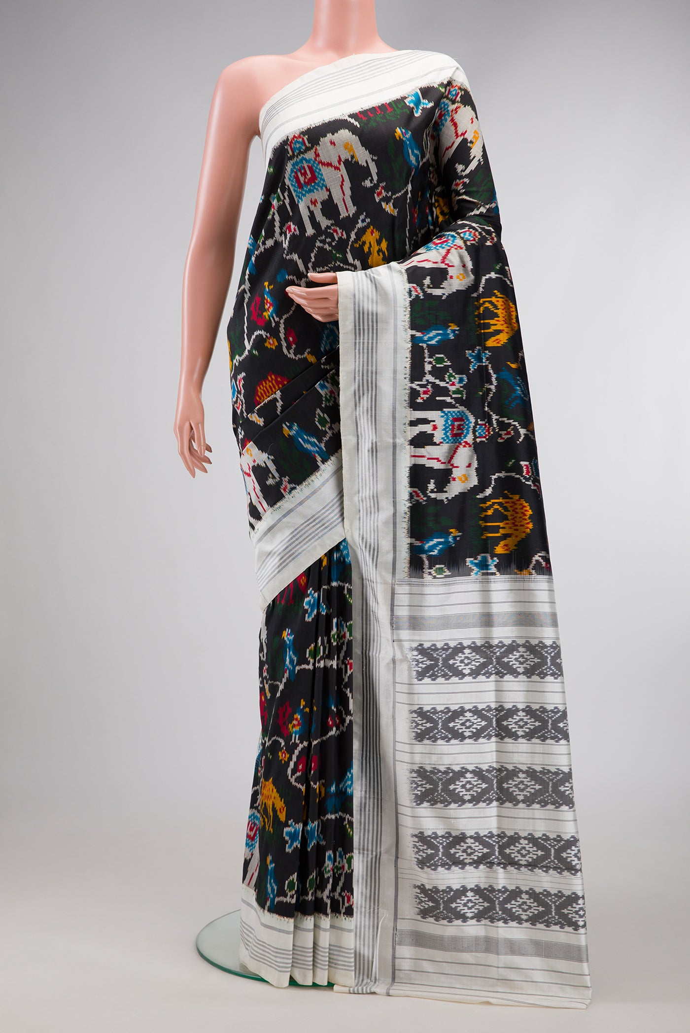 Black Dual Tone Double Ikat Saree with Ikat Print on the body and Thread Border.  displayed on a mannequin