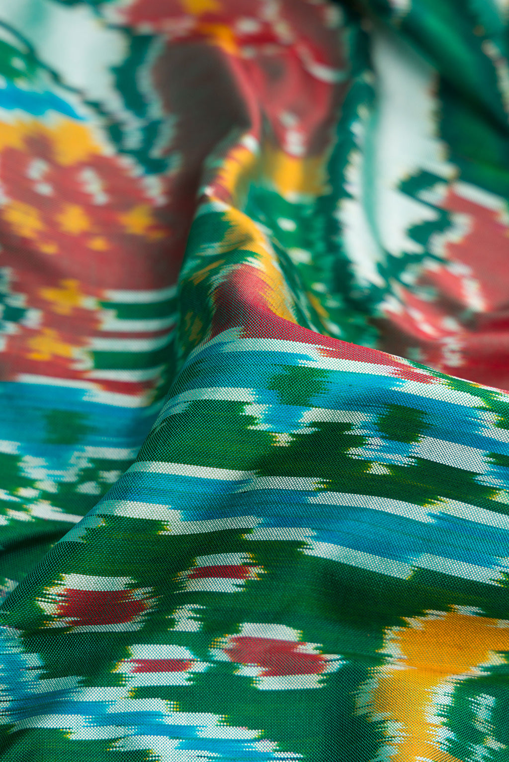 Close up of Pista Green Dual Tone Double Ikat Saree with Ikat Print on the body and Ikat Border.  displaying folds
