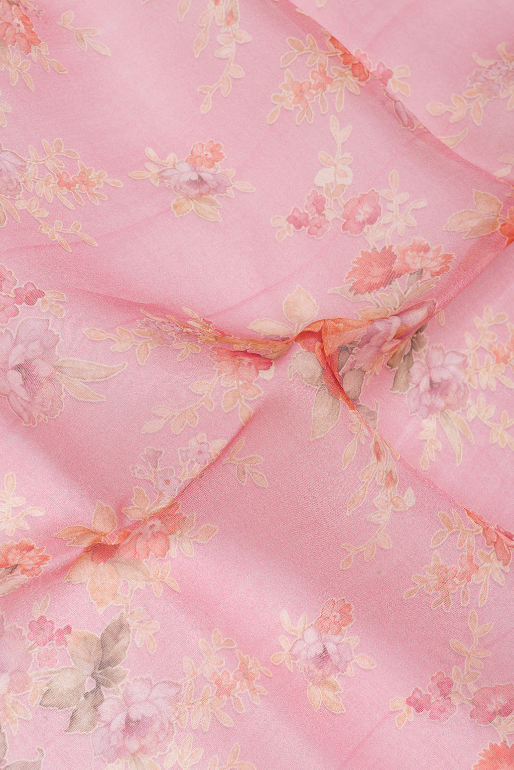 Close up of Coral Organza Silk Saree with Floral Print on the body and Without Border.  displaying folds