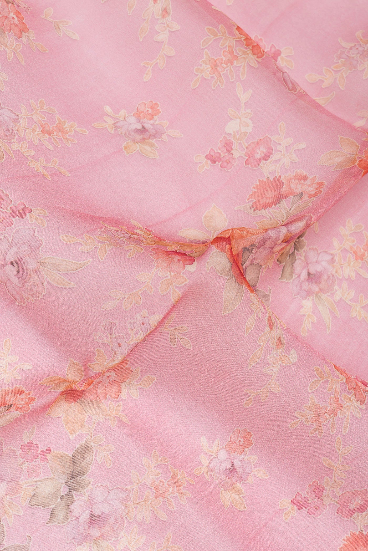 Close up of Coral Organza Silk Saree with Floral Print on the body and Without Border.  displaying folds
