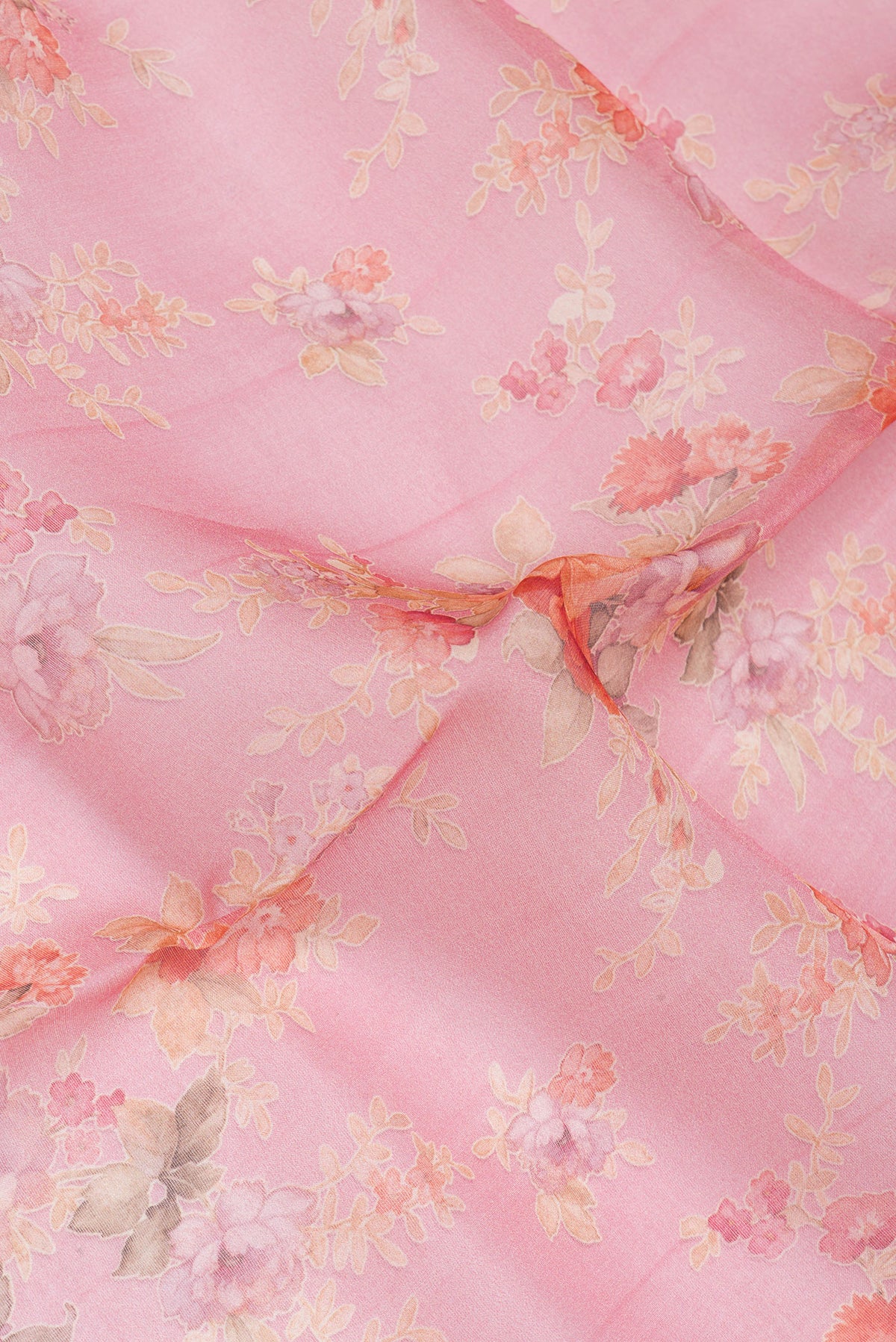Close up of Coral Organza Silk Saree with Floral Print on the body and Without Border.  displaying folds