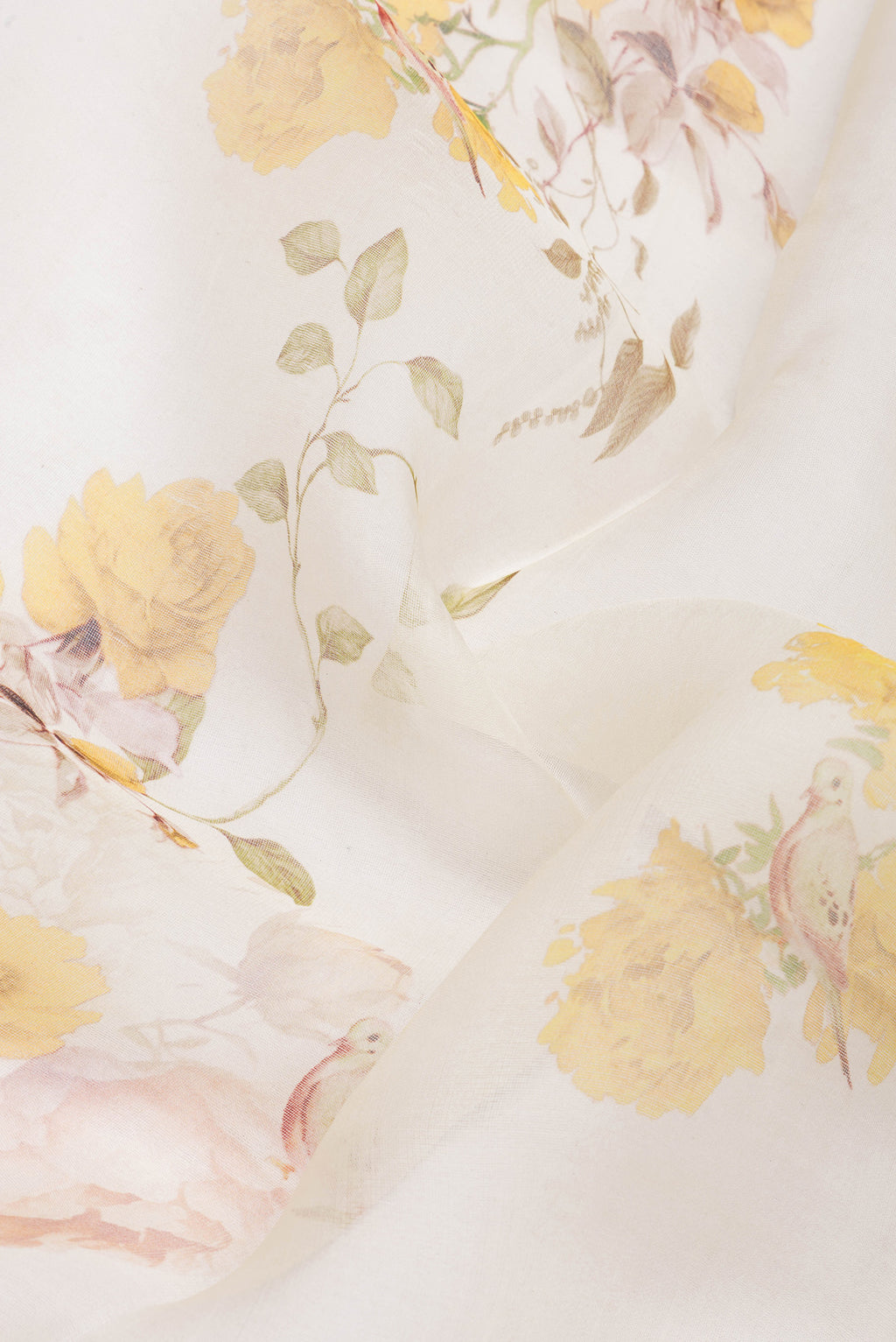 Close up of Off White Organza Silk Saree with Floral Print on the body and Plain Border.  displaying folds